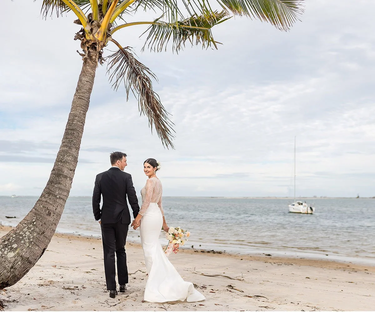 Bride and Groom walk along the beach at their Caloundra Wedding