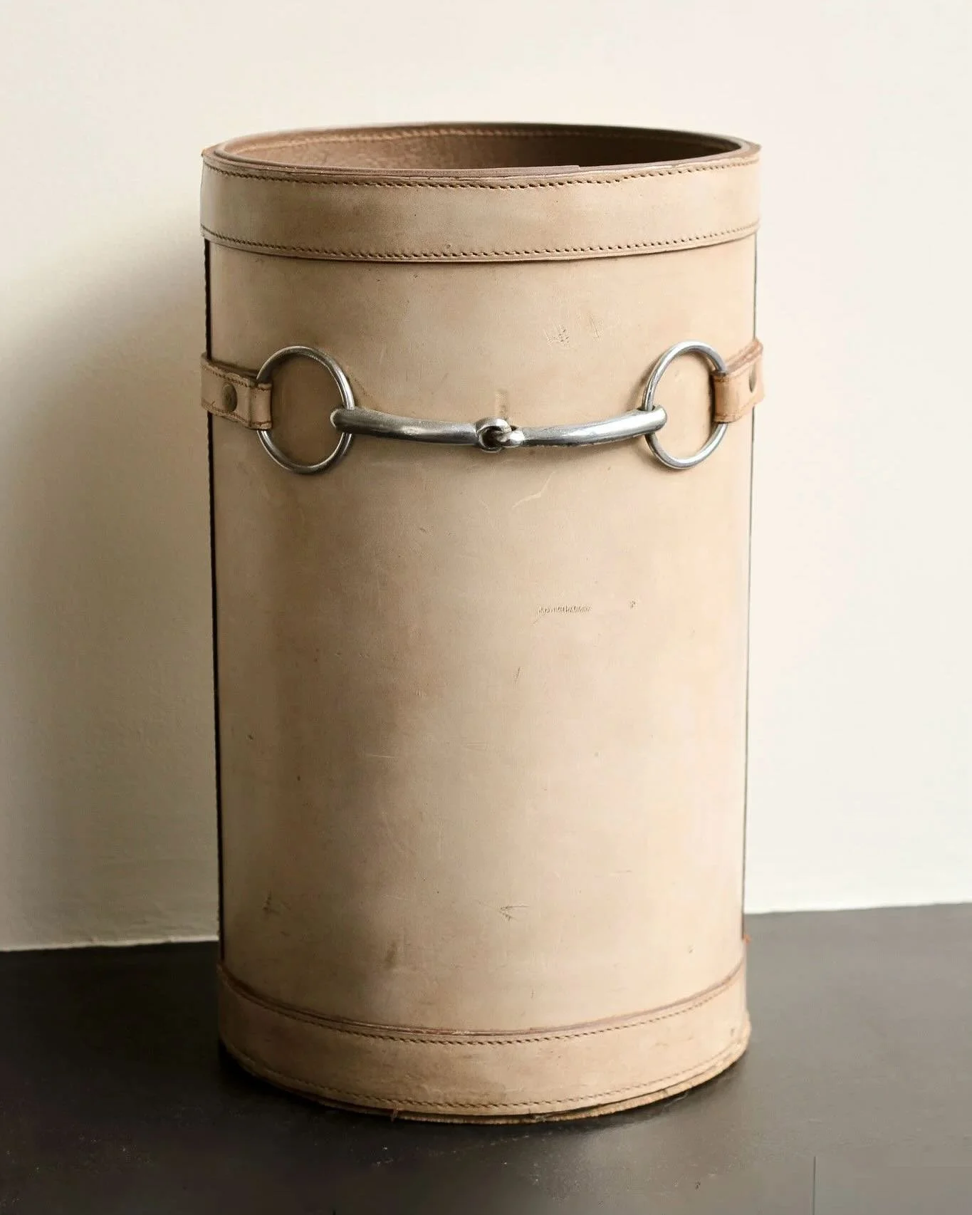 Available; A stitched nude leather wastepaper bin with chrome horsebit detail in the style of Herm&eacute;s. Could also be used as an umbrella stand.

French, C1950

Height: 45cm
Diameter: 27cm