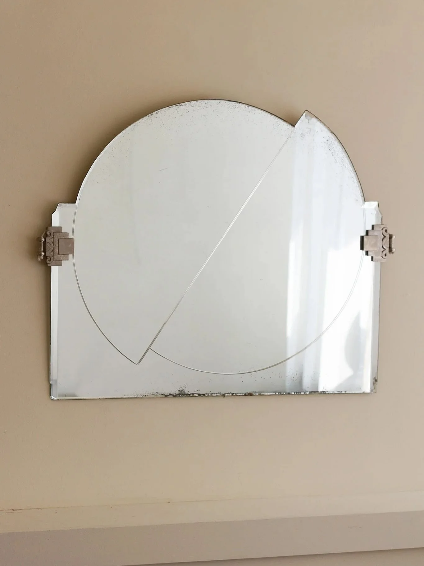 An art deco wall mirror with decorative silvered mounts and an asymmetric geometric shape.

French, 1920s

Height: 60cm
Width: 76cm