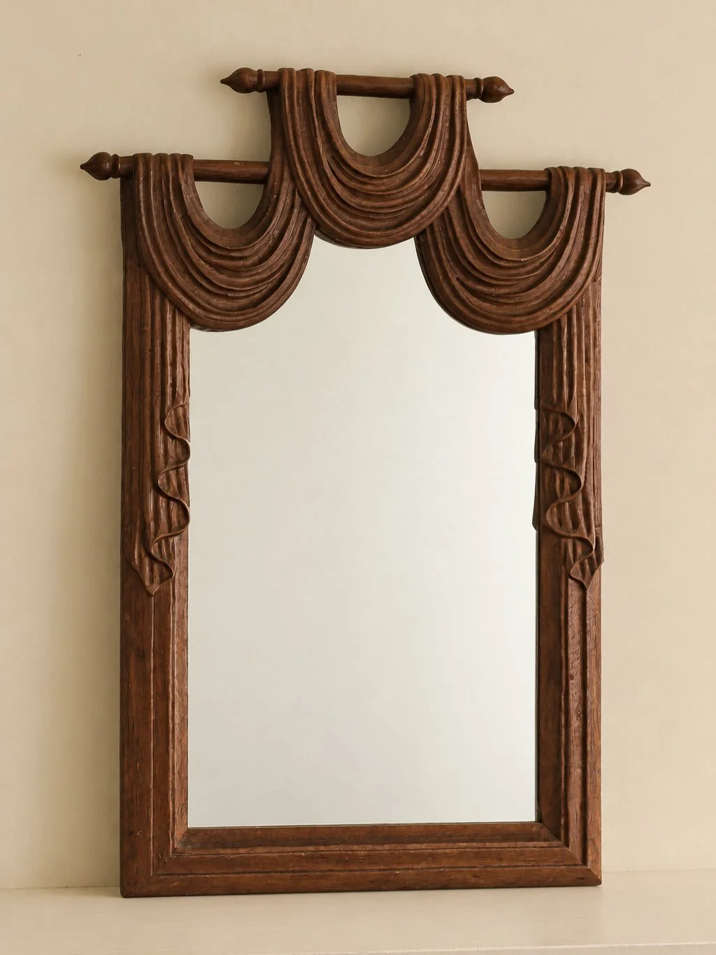 Now available; a trompe l&rsquo;oeil carved draped detail wood wall mirror.

Mid to late 20th century.

Height: 60cm
Width: 35cm
Depth: 3cm
