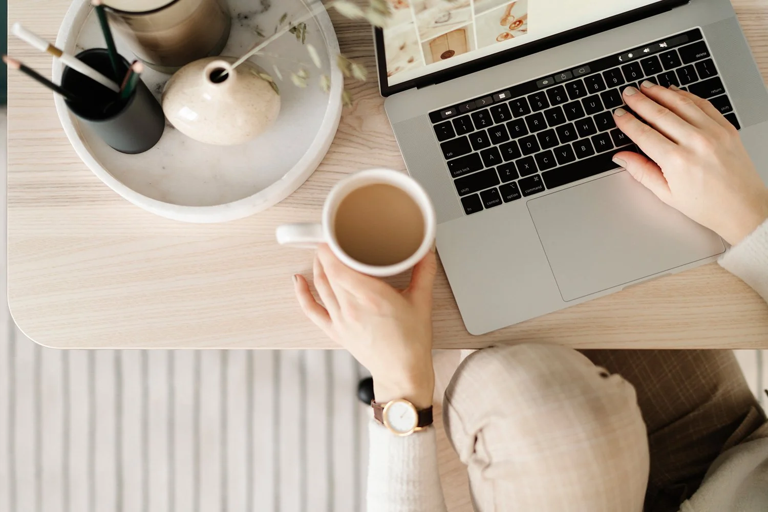 Nainen naputtelee kannettavaa tietokonetta työpöydällään.