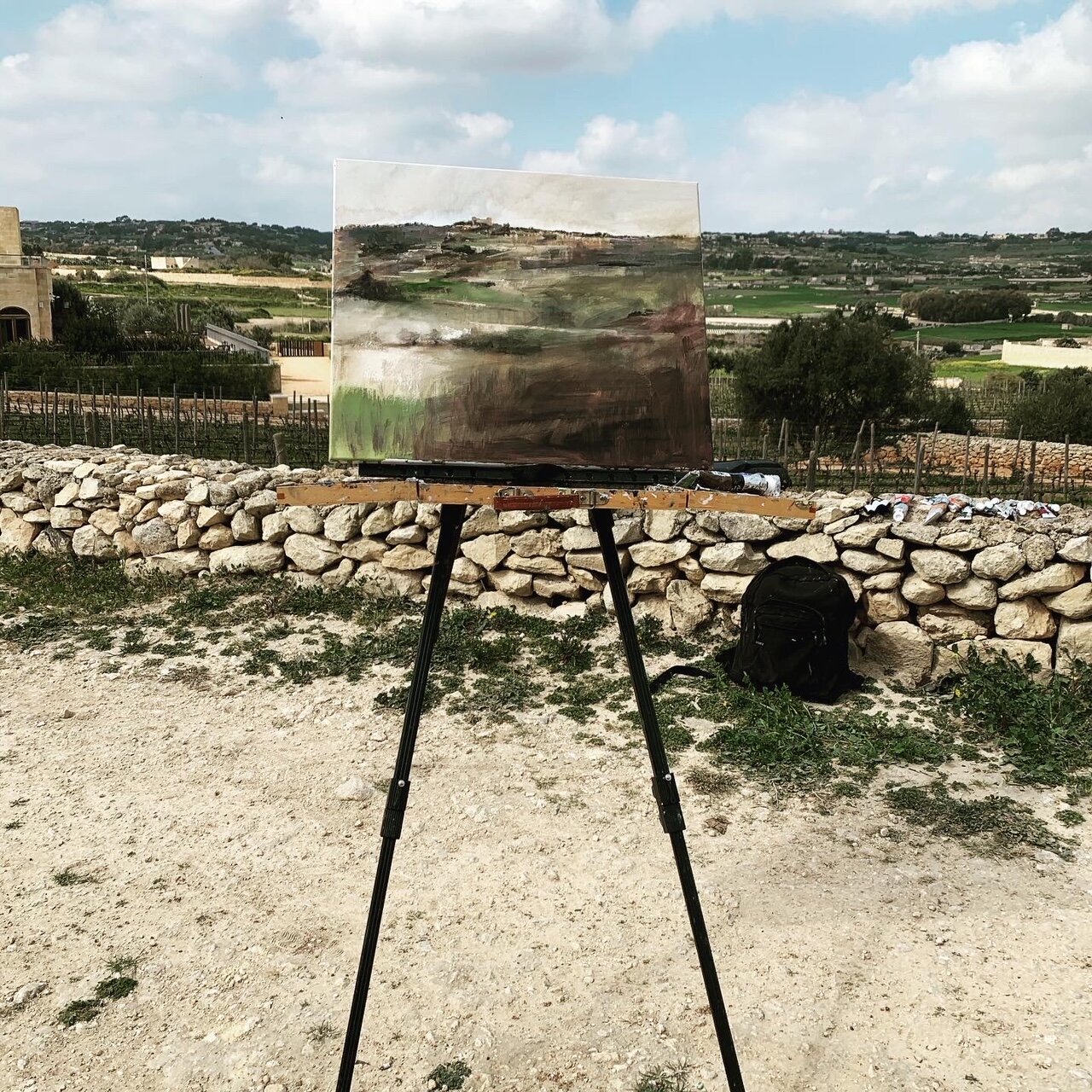 Painting on the easel on location blending seamlessly in the horizon and the countryside.