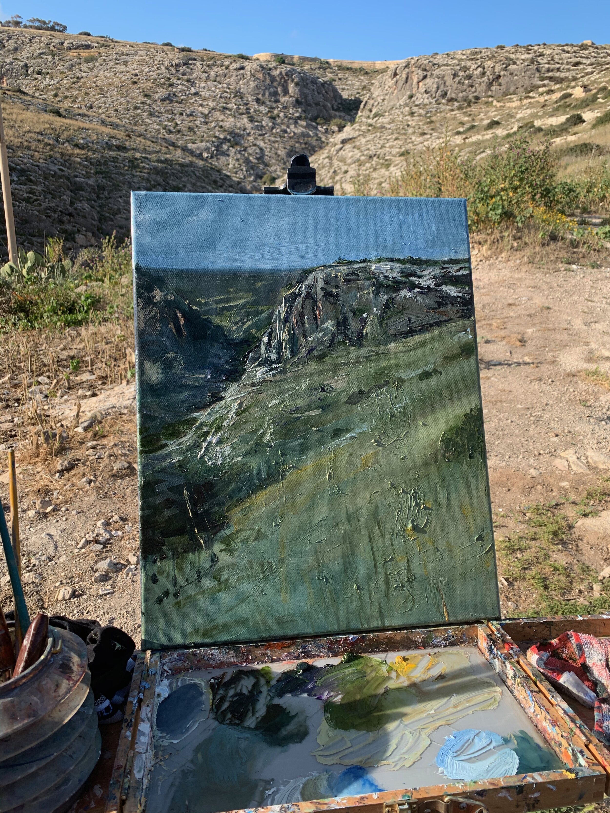 Zurrieq painted en plein air, painting on the easel, with its subject, the valley behind it.