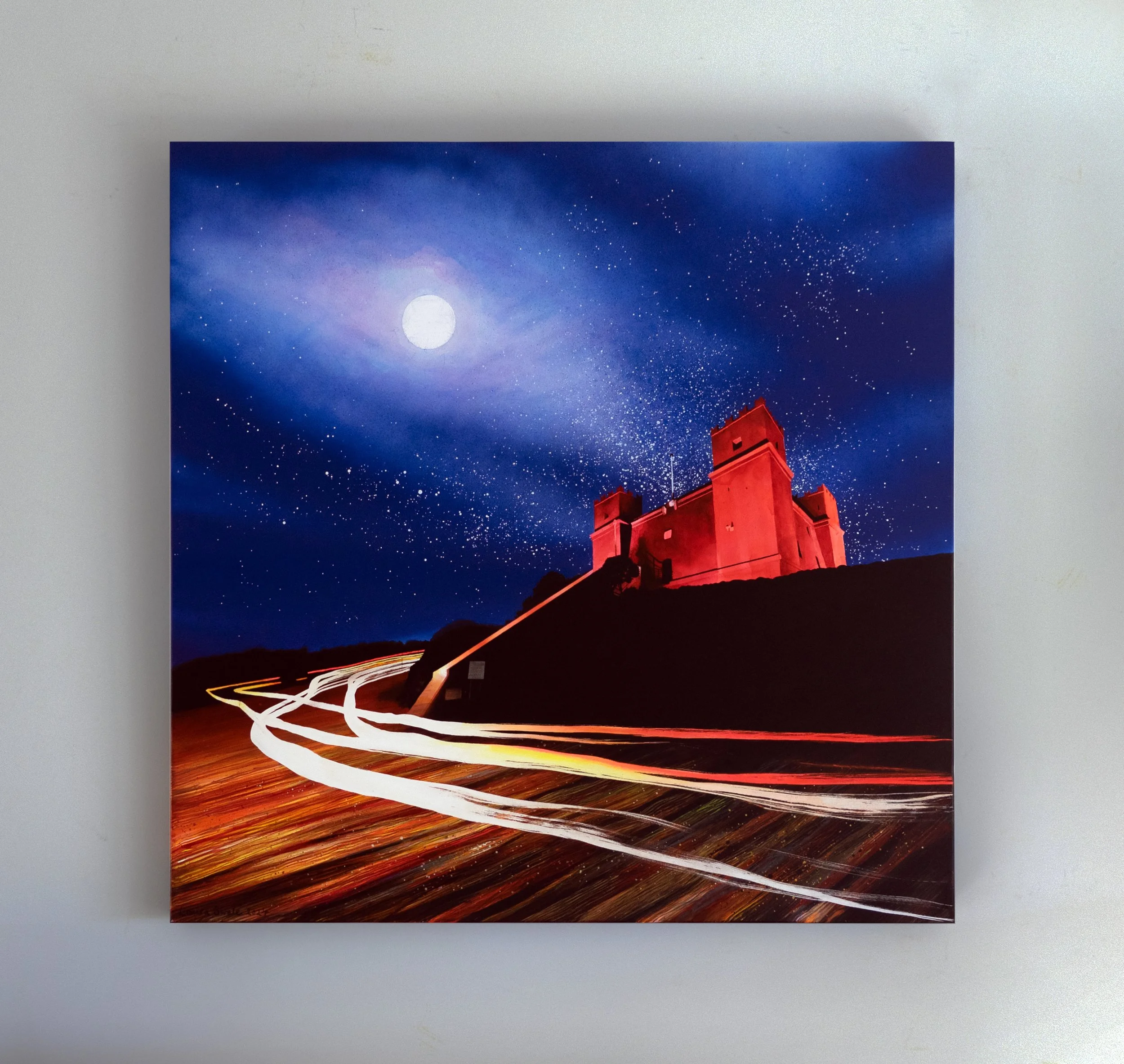 Long-exposure photograph of a red-lit observatory under a star-filled night sky, with the moon and swirling vehicle light trails.