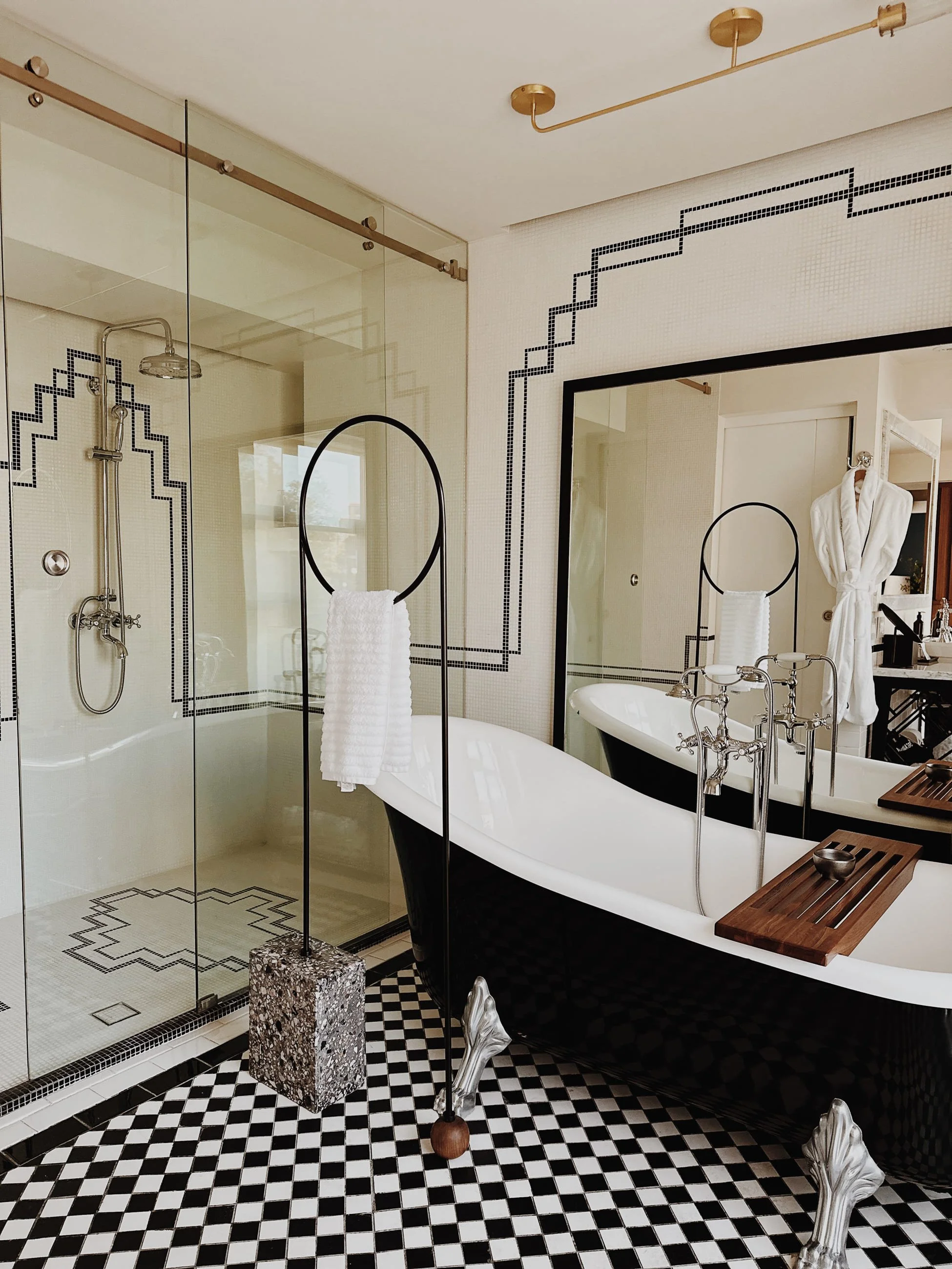 Luxurious bathroom with large bathtub, checkered floors, and large shower. 