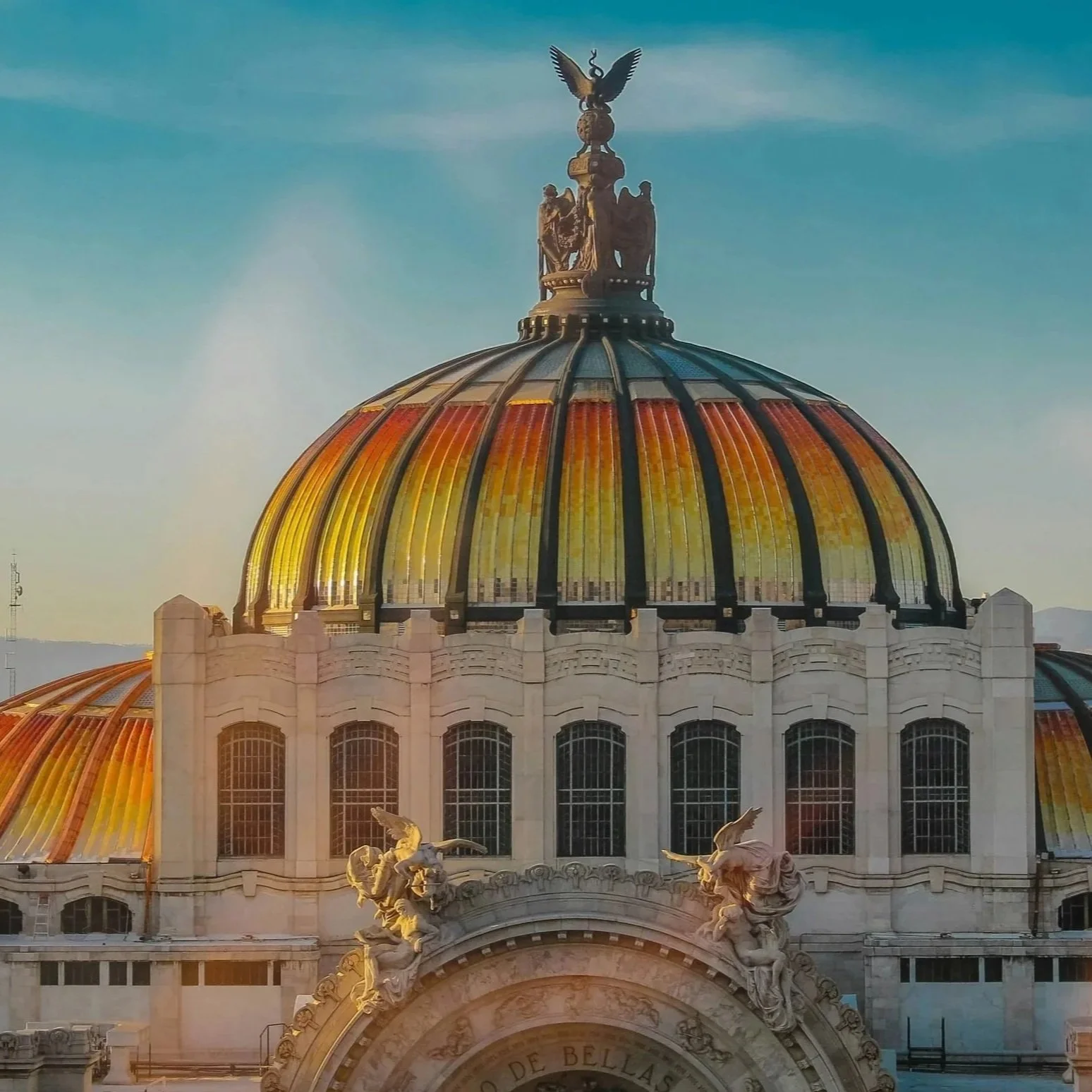 The colorful dome of Palacio de Bellas Artes in Mexico City against a blue sky