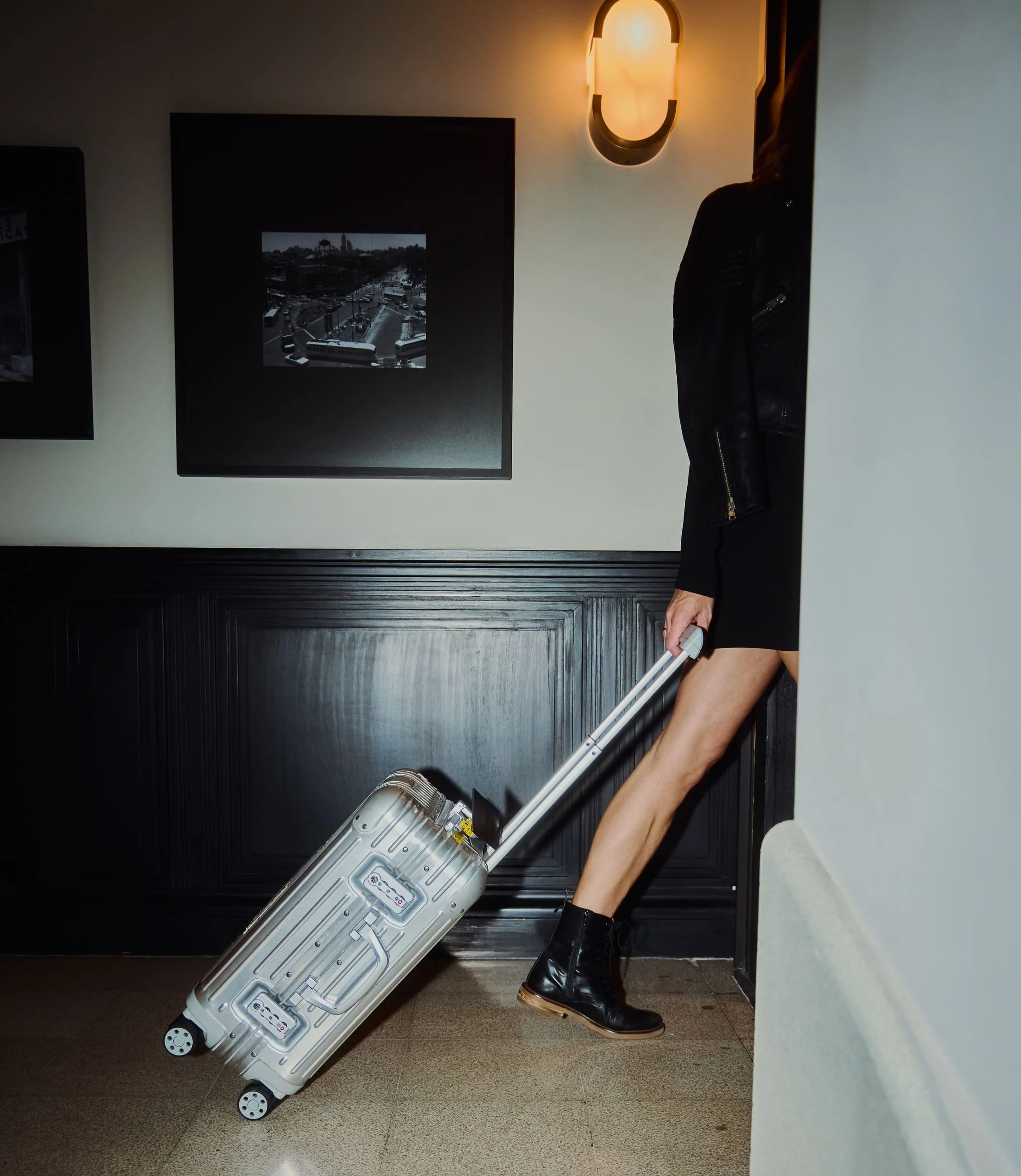 Woman pulling suitcase in hotel hallway