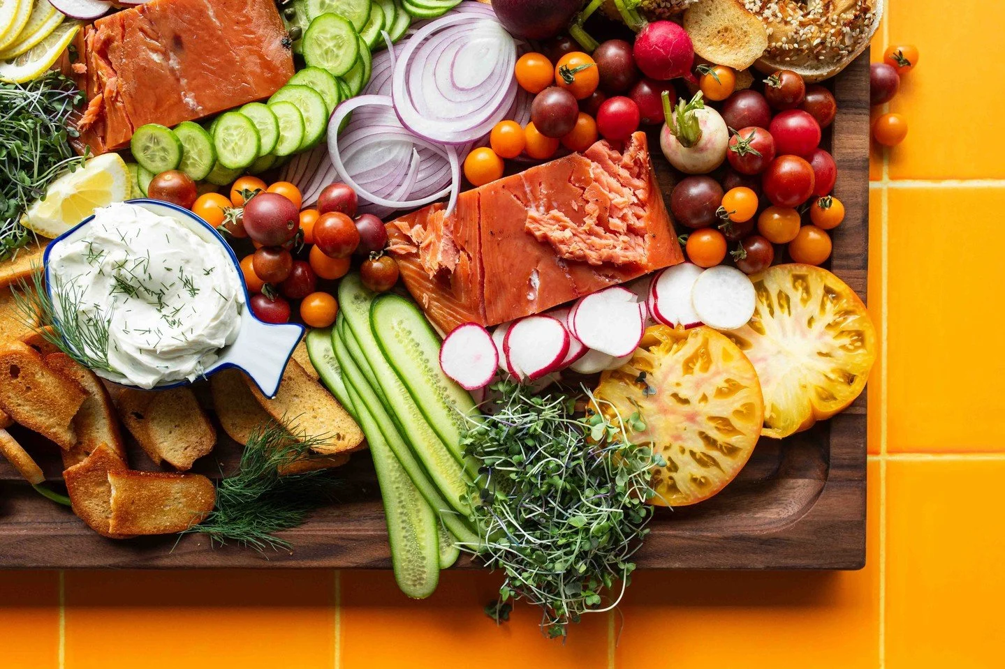 There&rsquo;s something joyful about putting together a spread like this&mdash;bright morning light, bagels still warm, layers of cucumber, radish, and that perfect slice of smoked salmon. It&rsquo;s abundant, it&rsquo;s approachable, and it&rsquo;s 