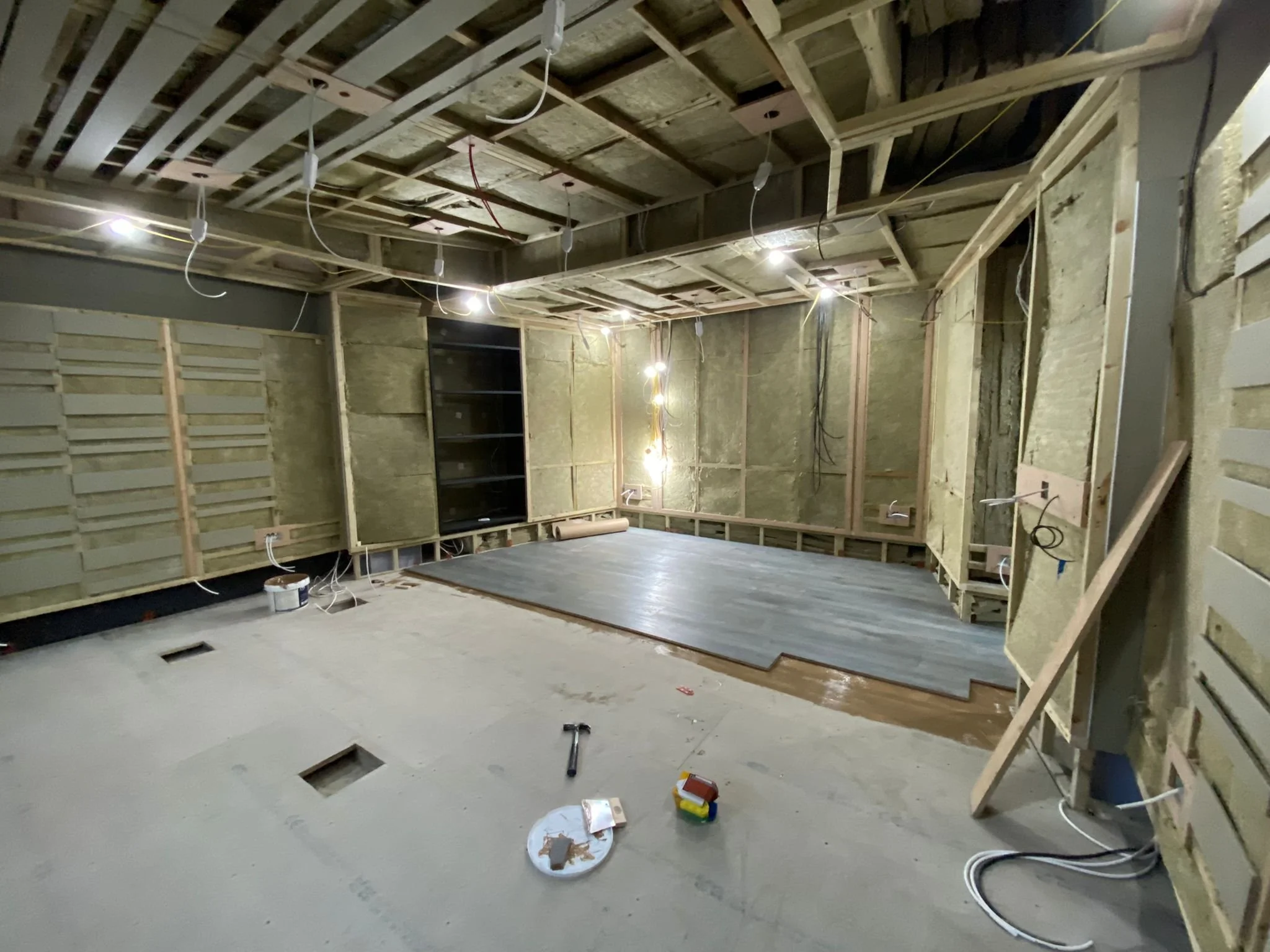 Works in progress in Studio 1 at Wired Masters, London, showing timber framing, acoustic treatment build-up and flooring installation.