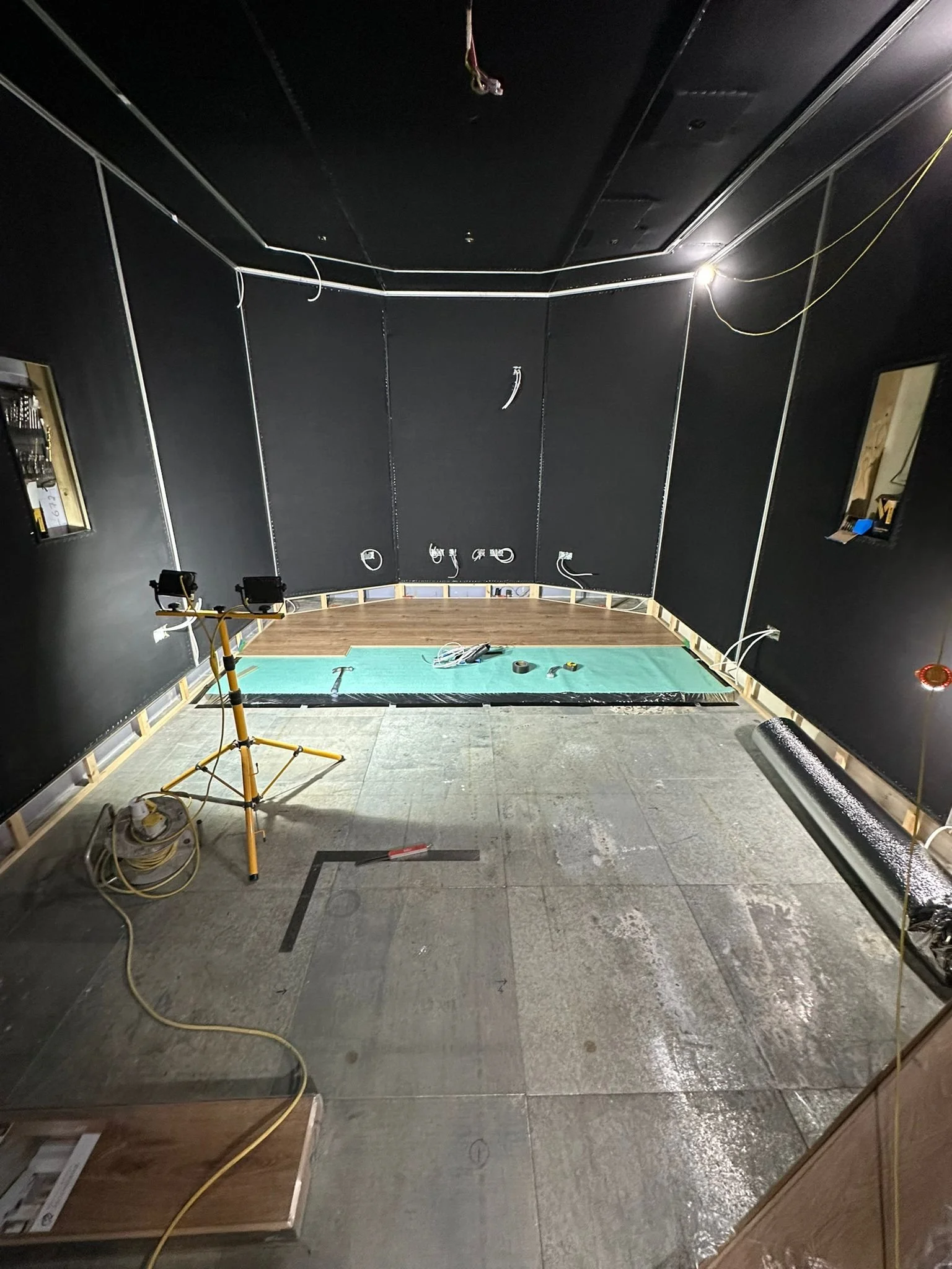Works in progress in the Dolby Atmos studio at Wired Masters, London, showing flooring installation and acoustic fabric with integrated LED channels.