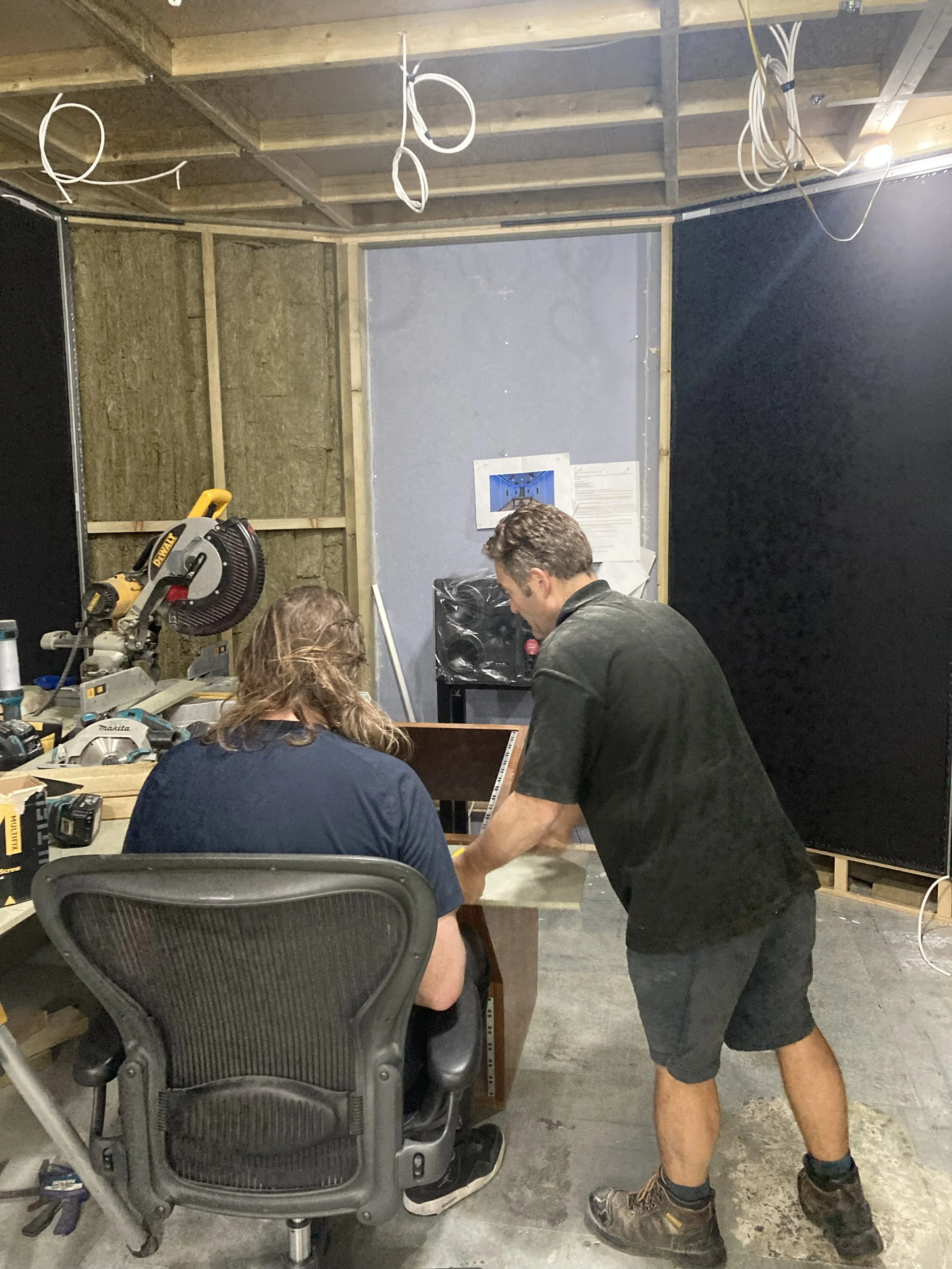 Works in progress at Wired Masters, London, showing client and tradesman reviewing joinery at a temporary workstation.