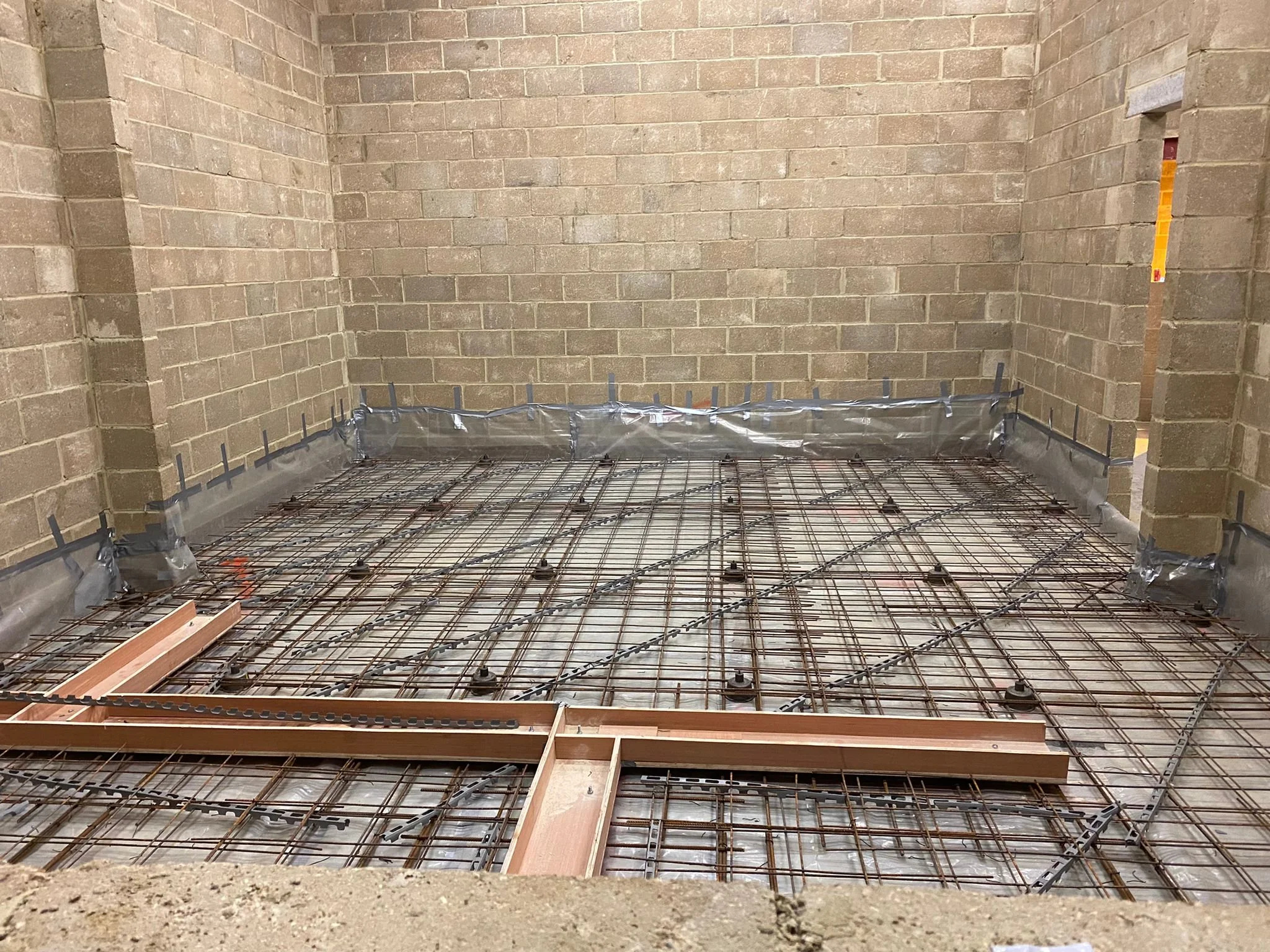 Works in progress at Wired Masters, London, showing jack-up floating floor reinforcement and cable channels prepared for the concrete pour.