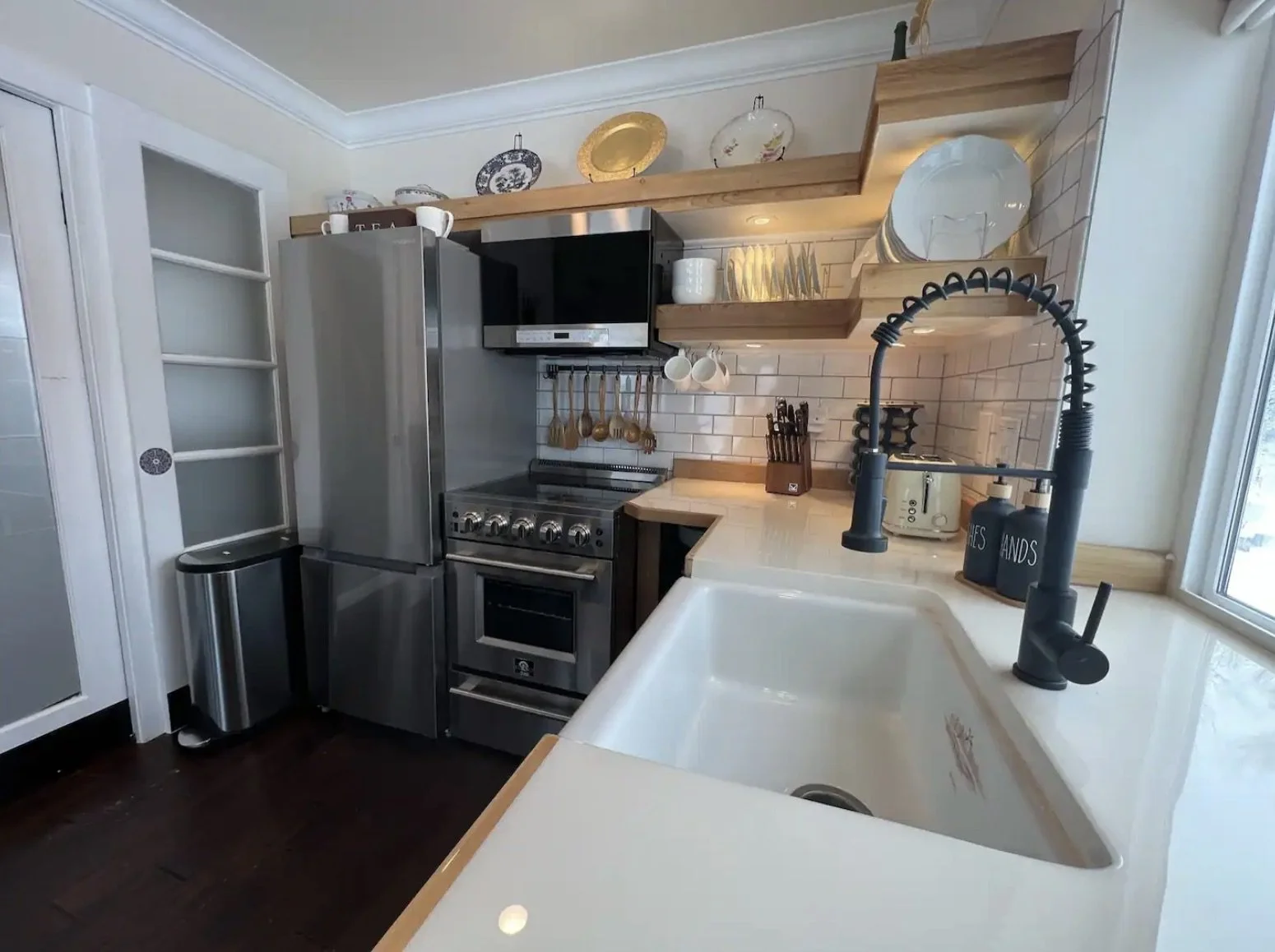 Completed kitchen interior of a detached accessory dwelling unit in Denver, Colorado, built by Prenvalley Builders, featuring open shelving, stainless steel appliances, and a farmhouse sink.