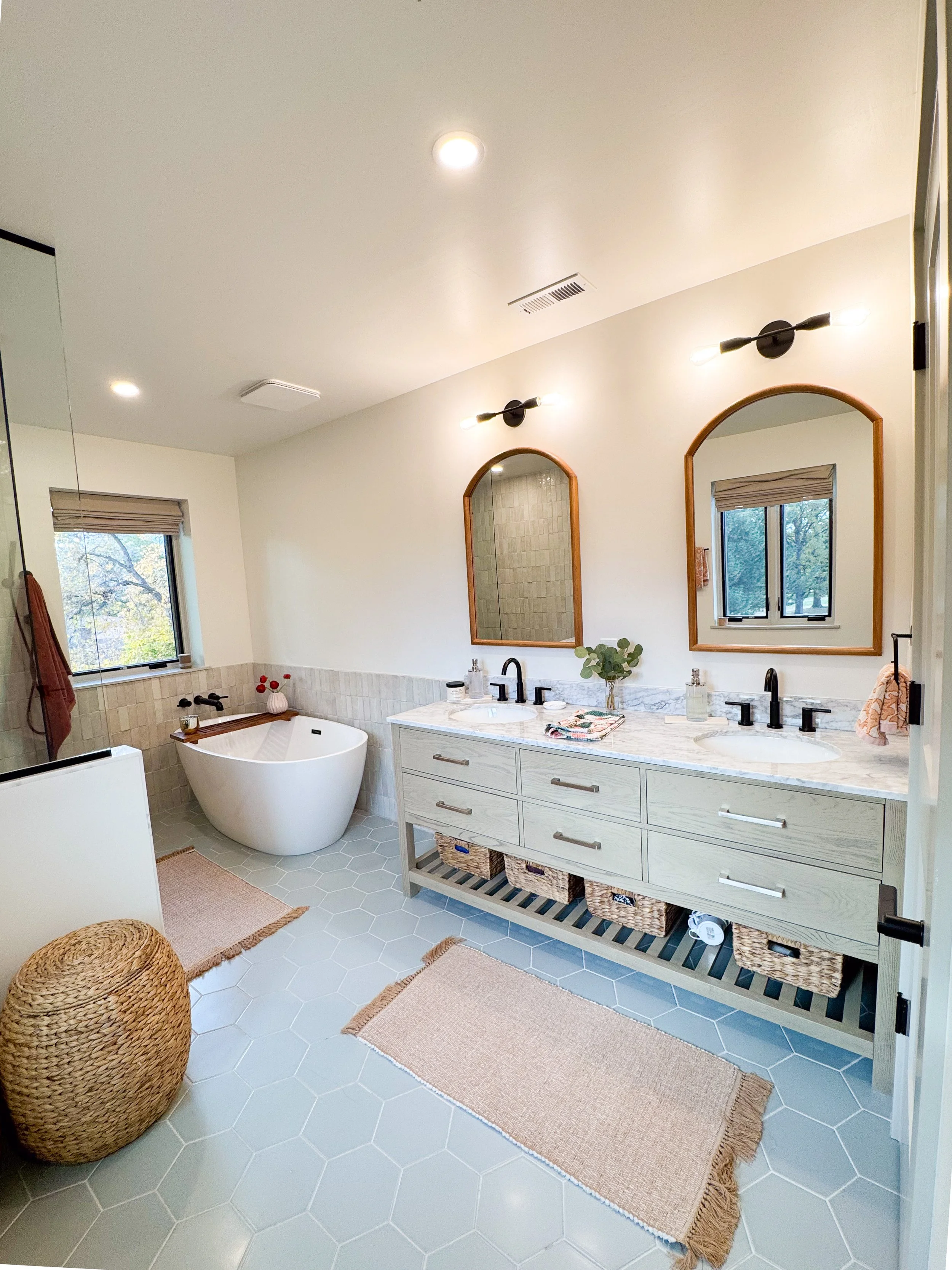Primary bathroom in a Denver pop-top renovation featuring a custom double vanity, freestanding soaking tub, and hex tile flooring