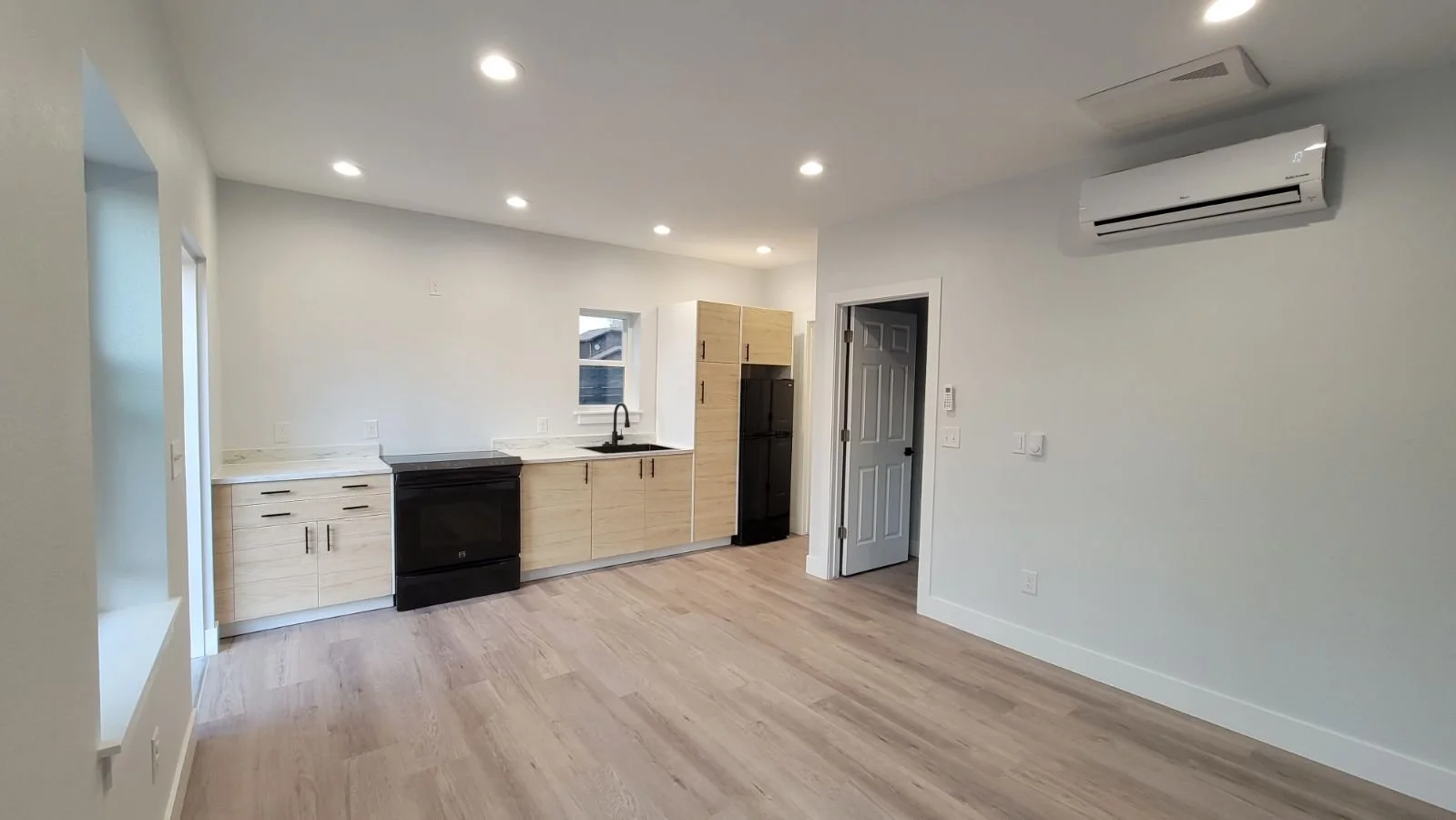 Open-concept interior of a finished accessory dwelling unit in Denver, featuring a compact kitchen, modern finishes, and efficient use of space by Prenvalley Builders.