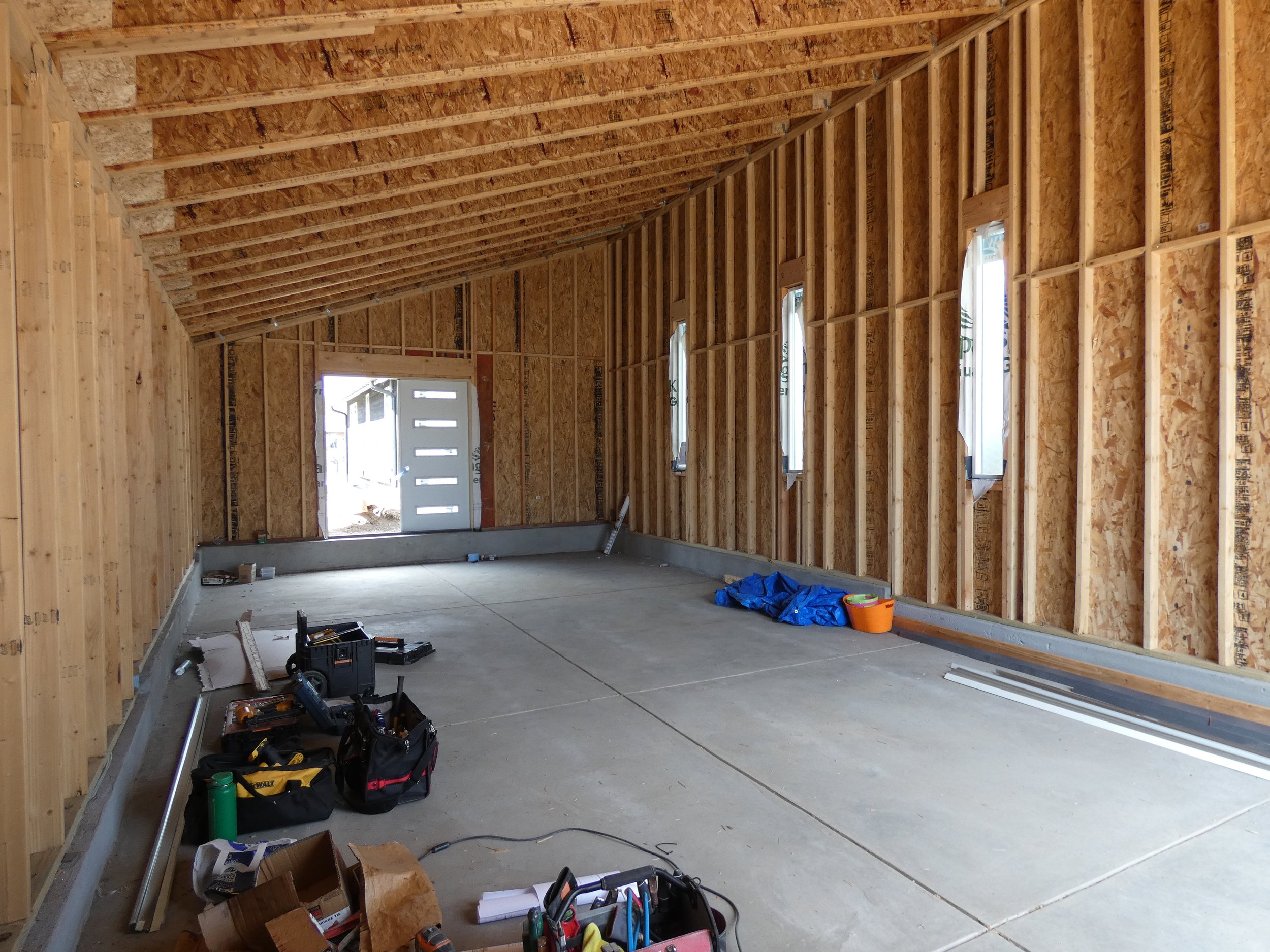 Interior view of a custom garage under construction in Denver’s Barnum neighborhood, showing exposed framing, a single-slope roof, and tall ceiling height for added storage capacity.