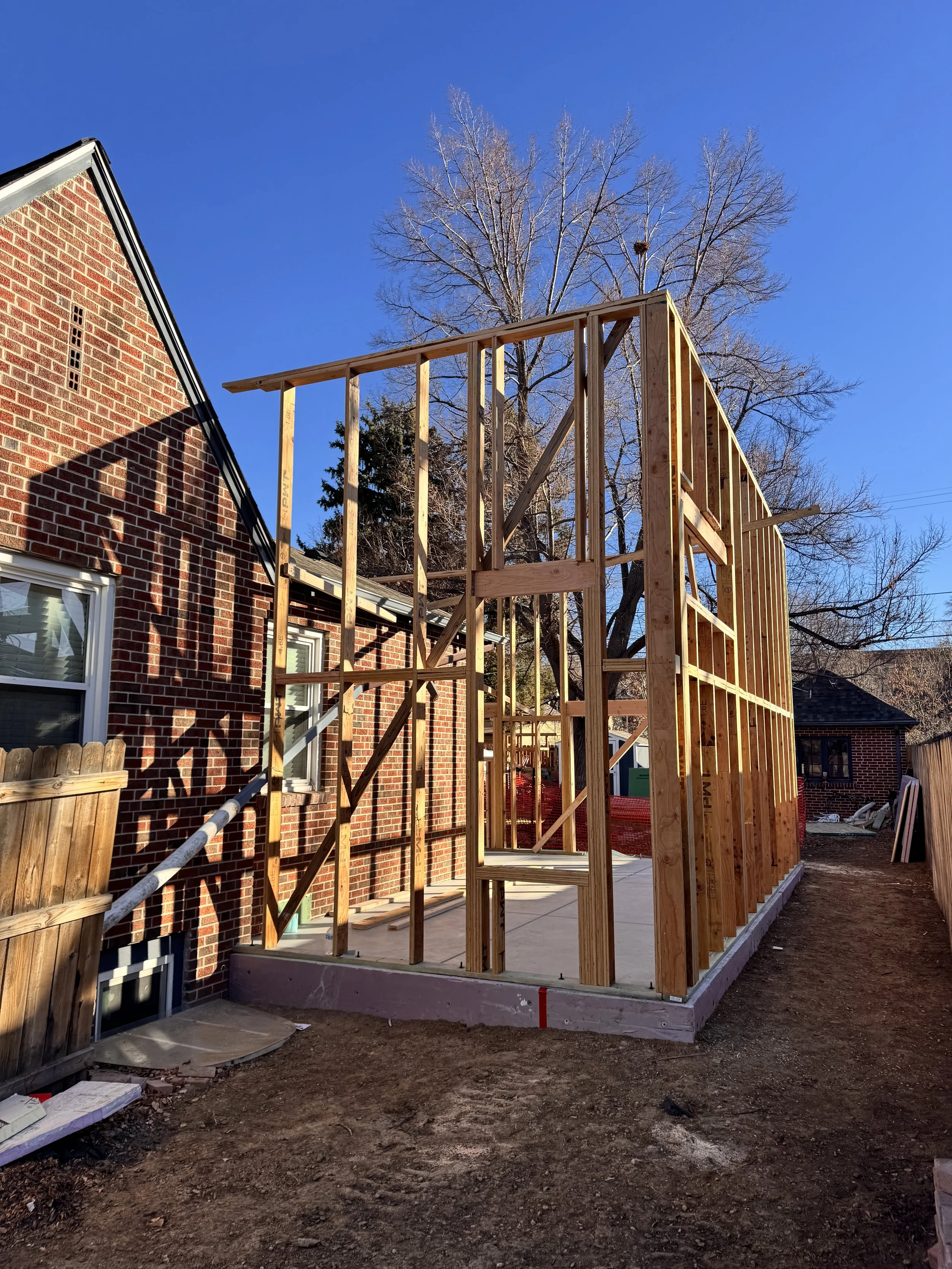 Vertical wall framing for a Denver home addition, carefully tied into an existing historic brick residence during construction by Prenvalley Builders.