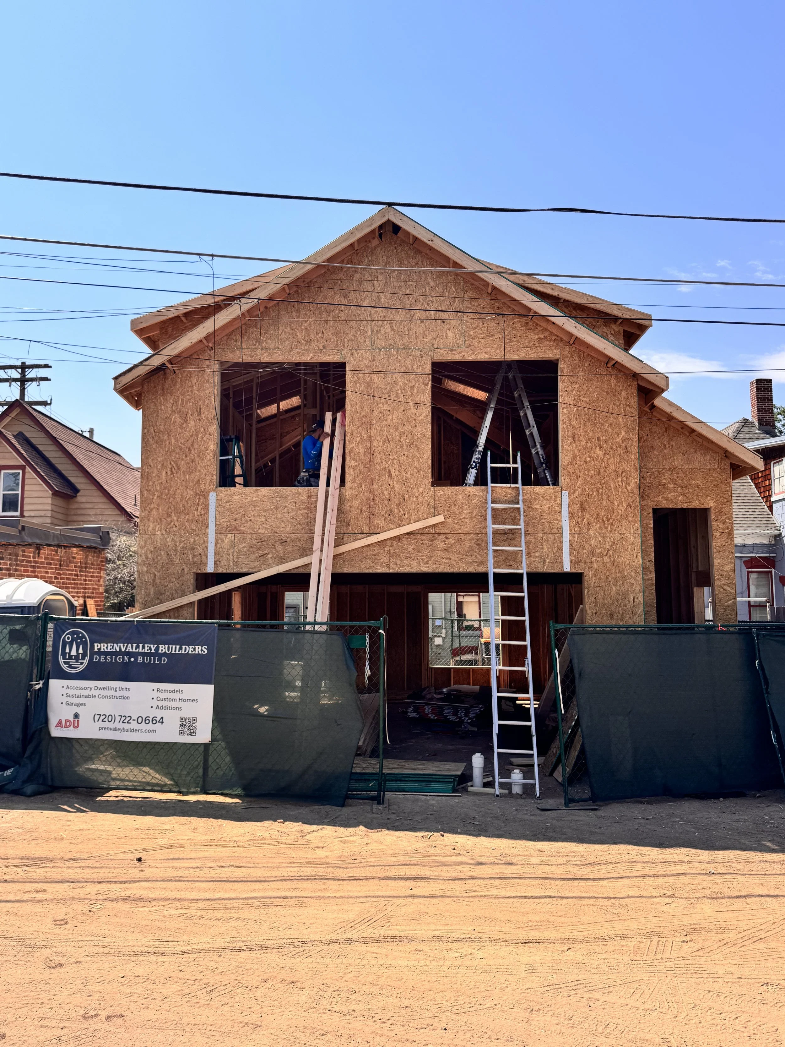 Two-story accessory dwelling unit framing in Denver showing structural shell, rooflines, and window openings during active construction