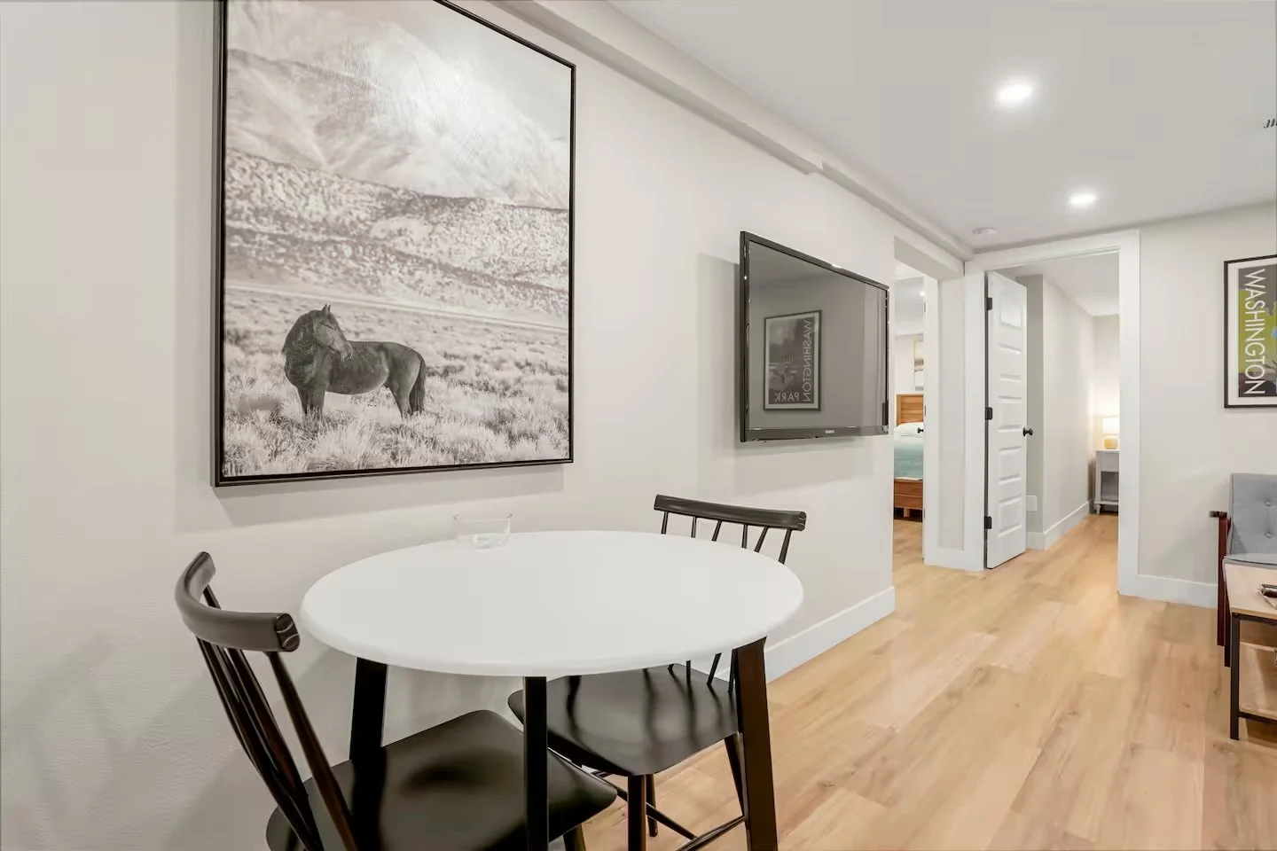Lower-level ADU dining area and hallway built as part of a Denver basement renovation, showcasing new flooring, lighting, and circulation between living spaces by Prenvalley Builders.