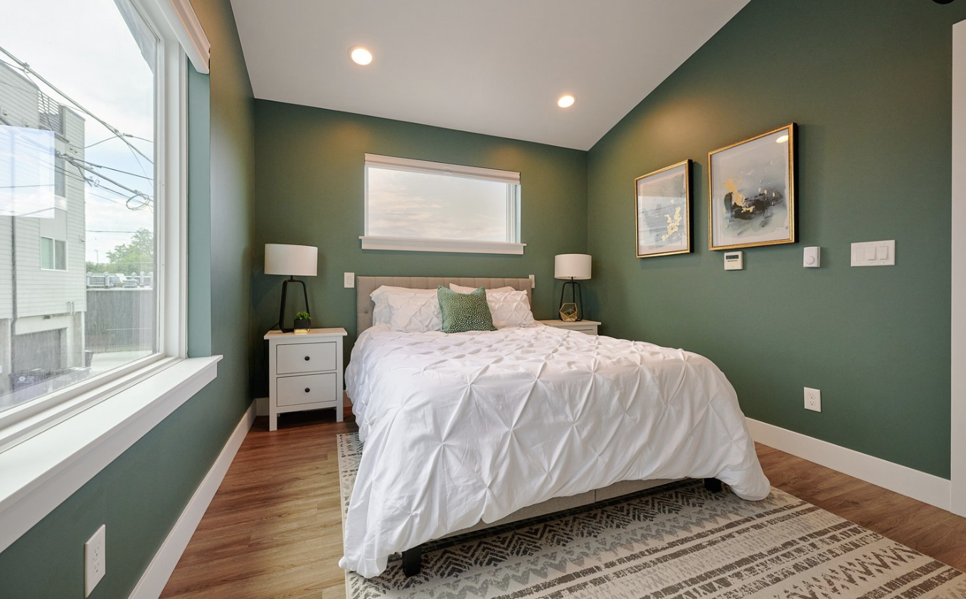 Bedroom inside a Denver accessory dwelling unit featuring recessed lighting, large windows, hardwood flooring, and a comfortable one-bedroom layout built by Prenvalley Builders.