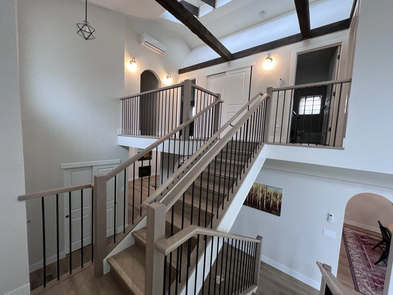 After photo of a redesigned interior staircase and upper-level landing following a full interior renovation in Golden, Colorado by Prenvalley Builders.