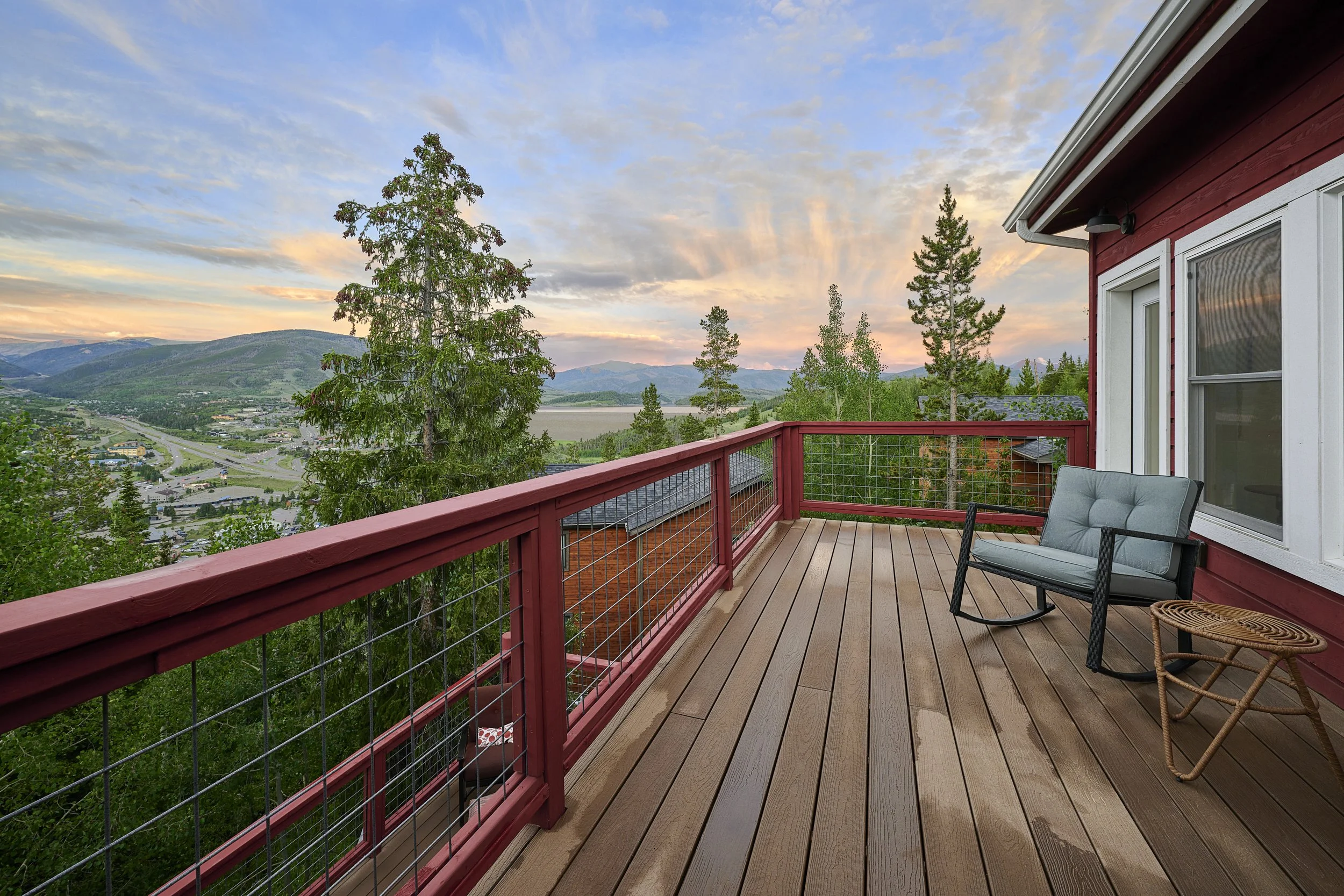 Finished upper-level balcony in a Silverthorne pop-top renovation, featuring completed decking, cable railing, and expansive mountain and Lake Dillon views from a second-story addition by Prenvalley Builders.