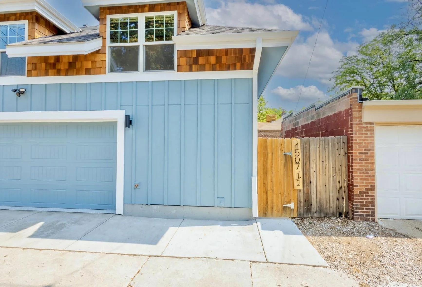 Finished exterior of a custom garage ADU in Denver’s Sunnyside neighborhood featuring vertical siding, cedar shingle accents, dormer windows, and a two-car garage built by Prenvalley Builders.