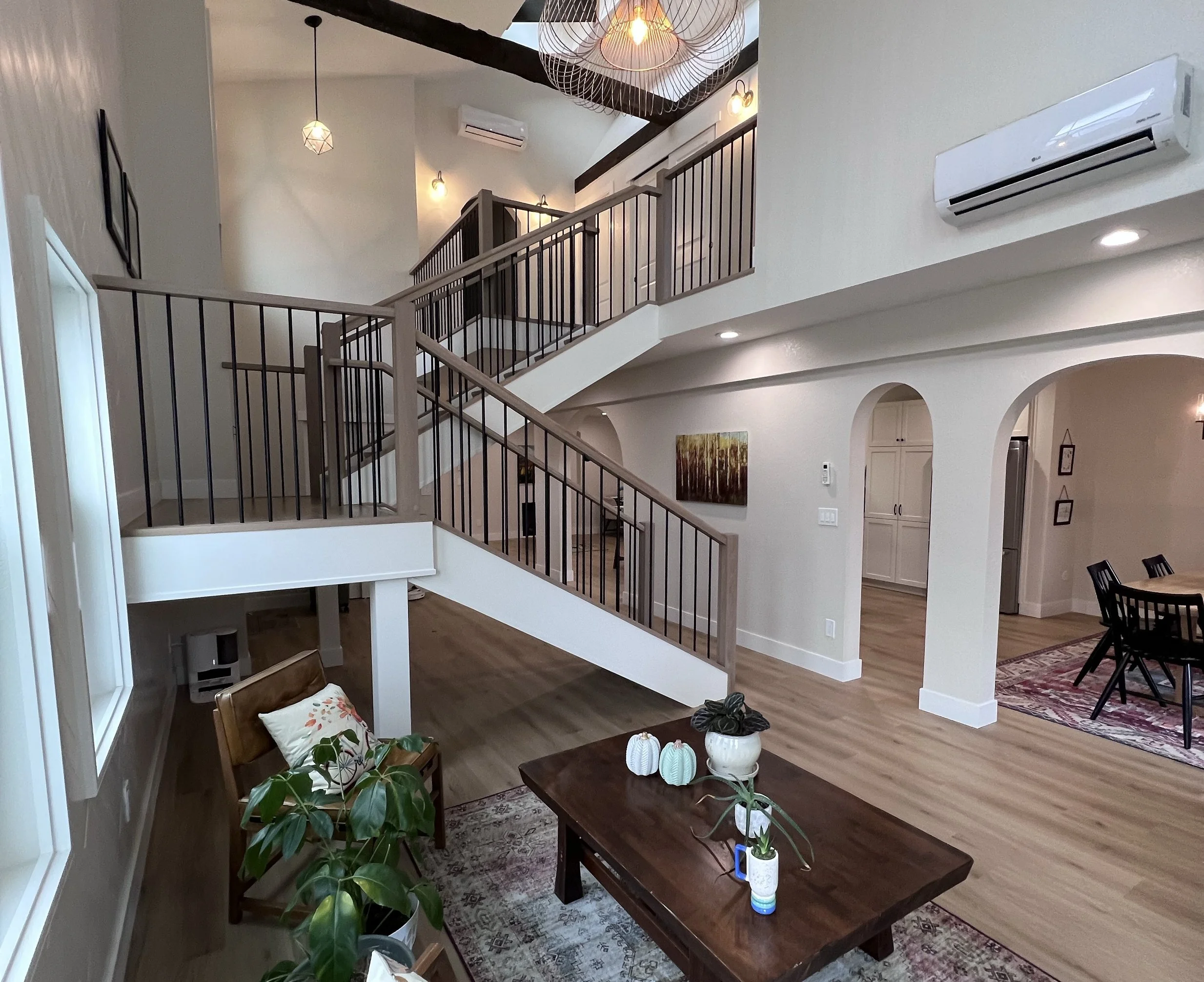 After photo of an open-concept living area with a redesigned staircase following a full interior renovation in Golden, Colorado by Prenvalley Builders.