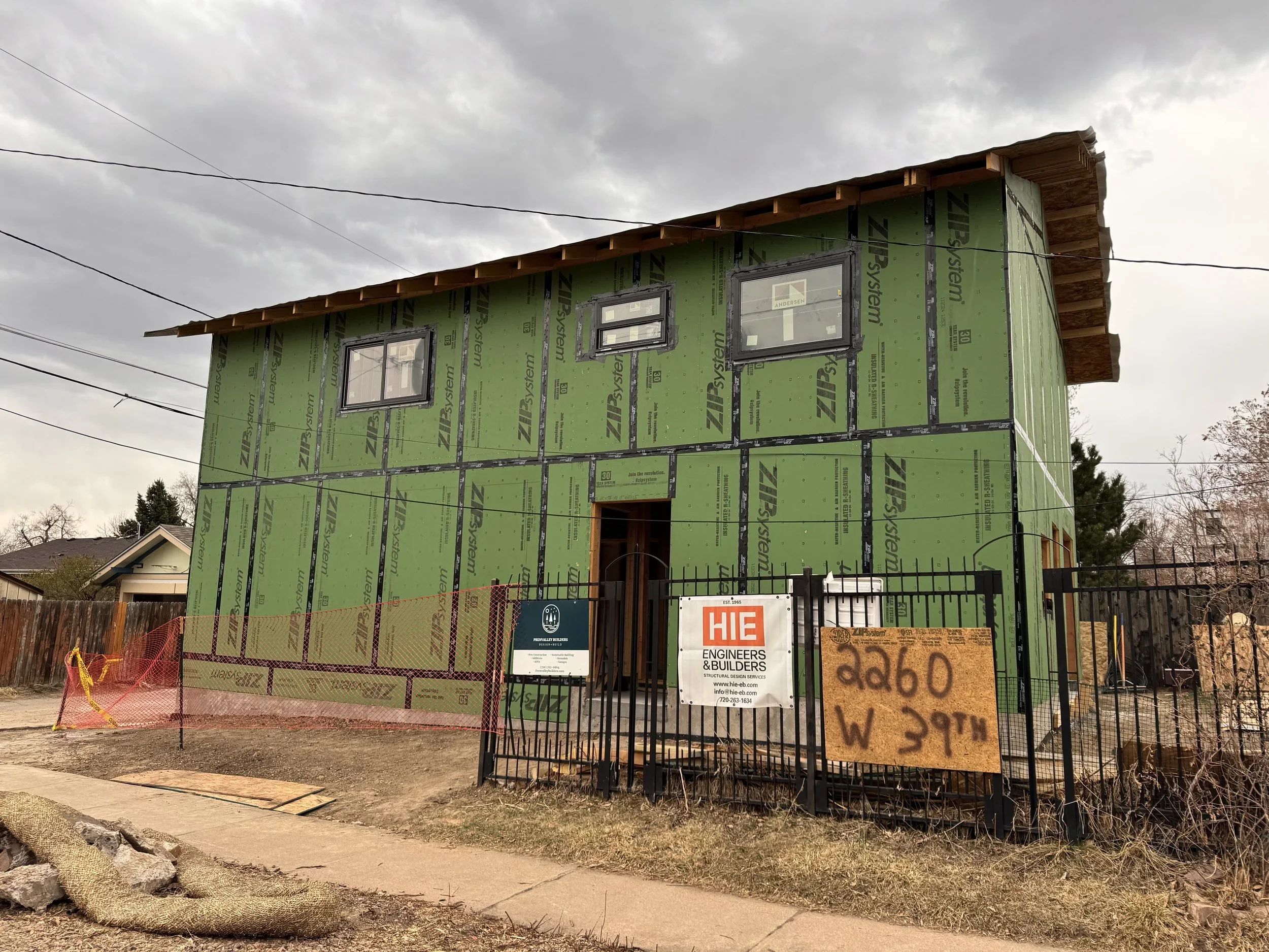 Two-story design-build ADU in Denver during framing with ZIP System sheathing and installed windows by Prenvalley Builders