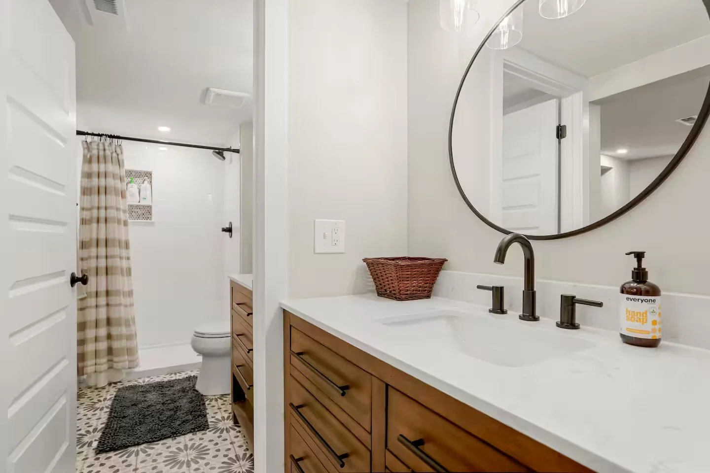 Lower-level ADU bathroom built as part of a Denver basement renovation, featuring a custom vanity, modern fixtures, and a full shower by Prenvalley Builders.