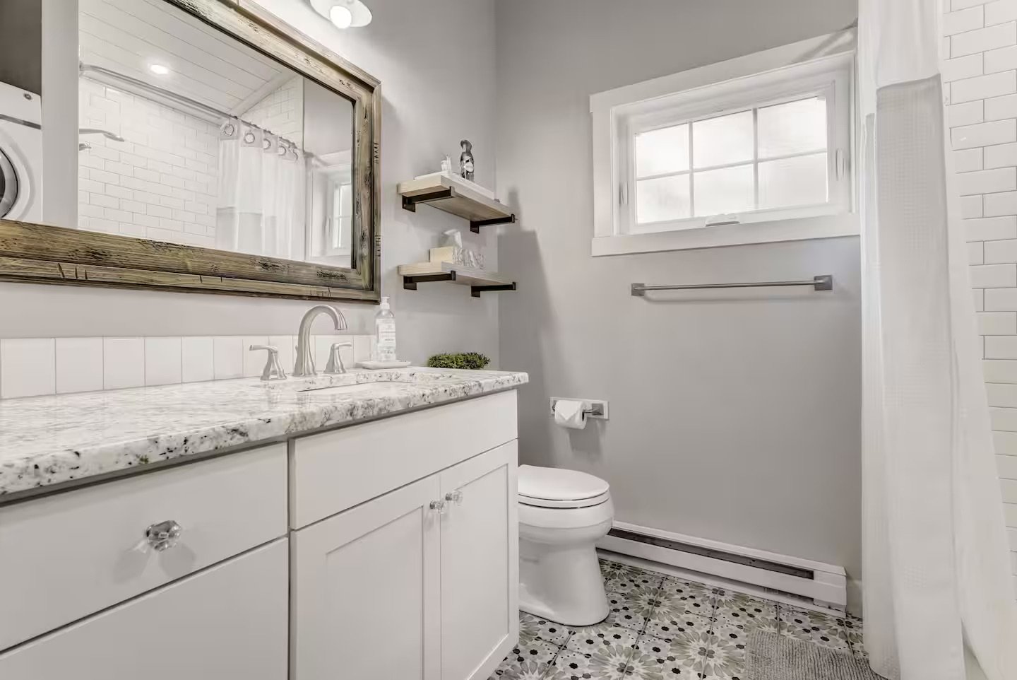 Bathroom vanity inside a detached accessory dwelling unit in Colorado Springs, Colorado, featuring white cabinetry, stone countertop, and compact, efficient layout.