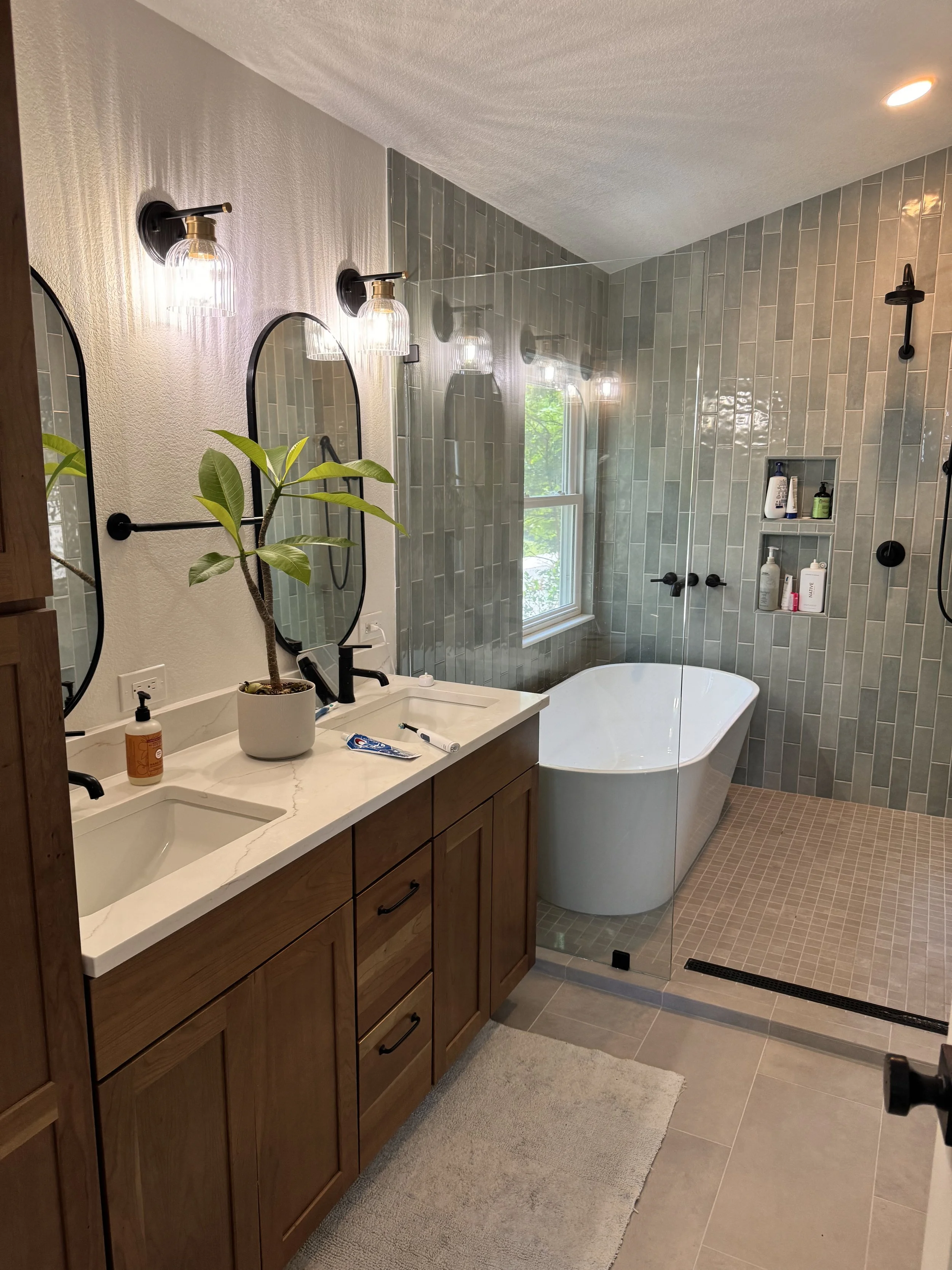 Completed primary bathroom remodel as part of a pop-top renovation in Golden, Colorado, featuring a double vanity, walk-in shower, and freestanding tub.