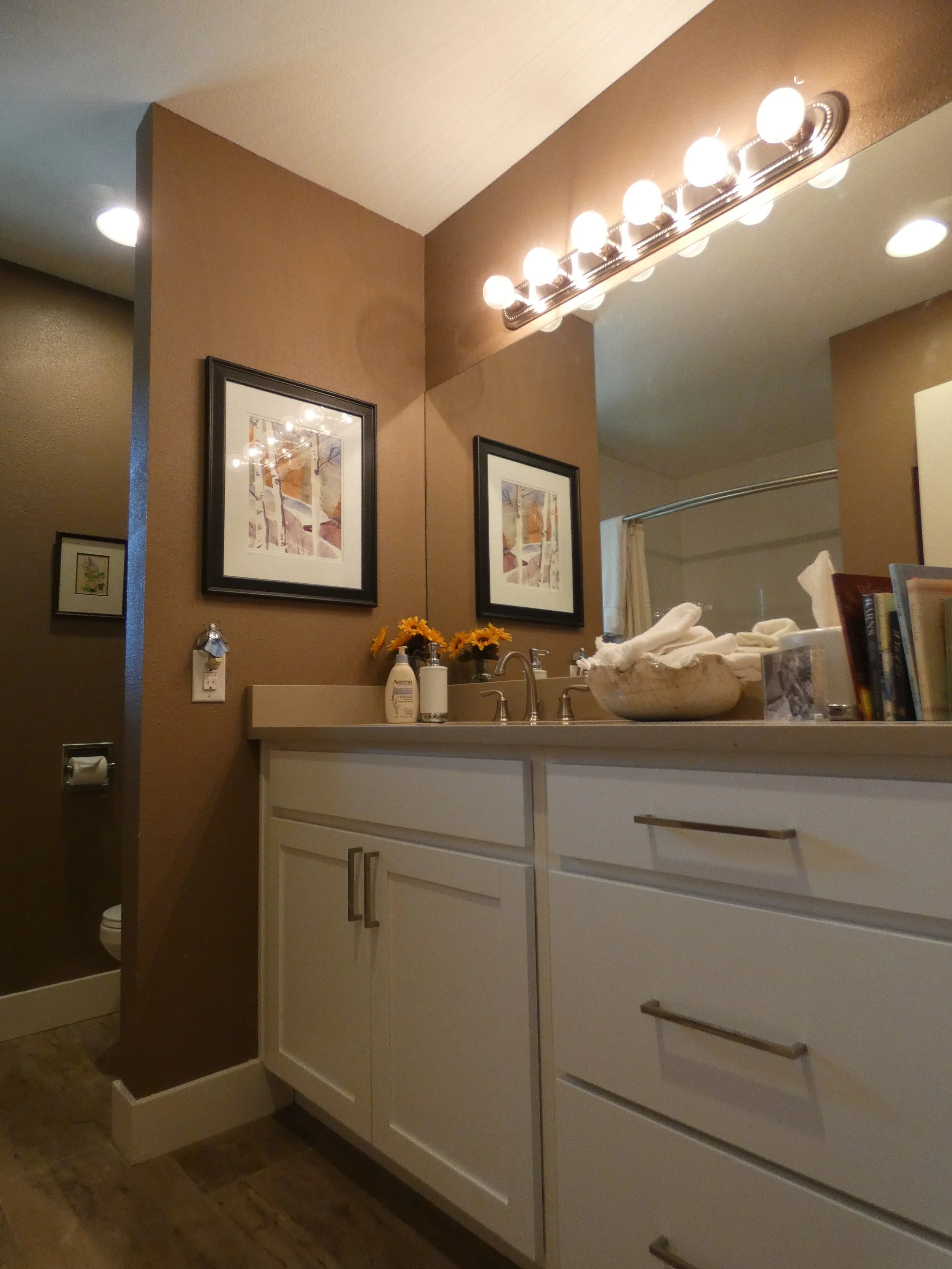 Finished bathroom vanity in a Denver home renovation, featuring custom cabinetry, stone countertop, updated lighting, and a clean, functional layout built by Prenvalley Builders.