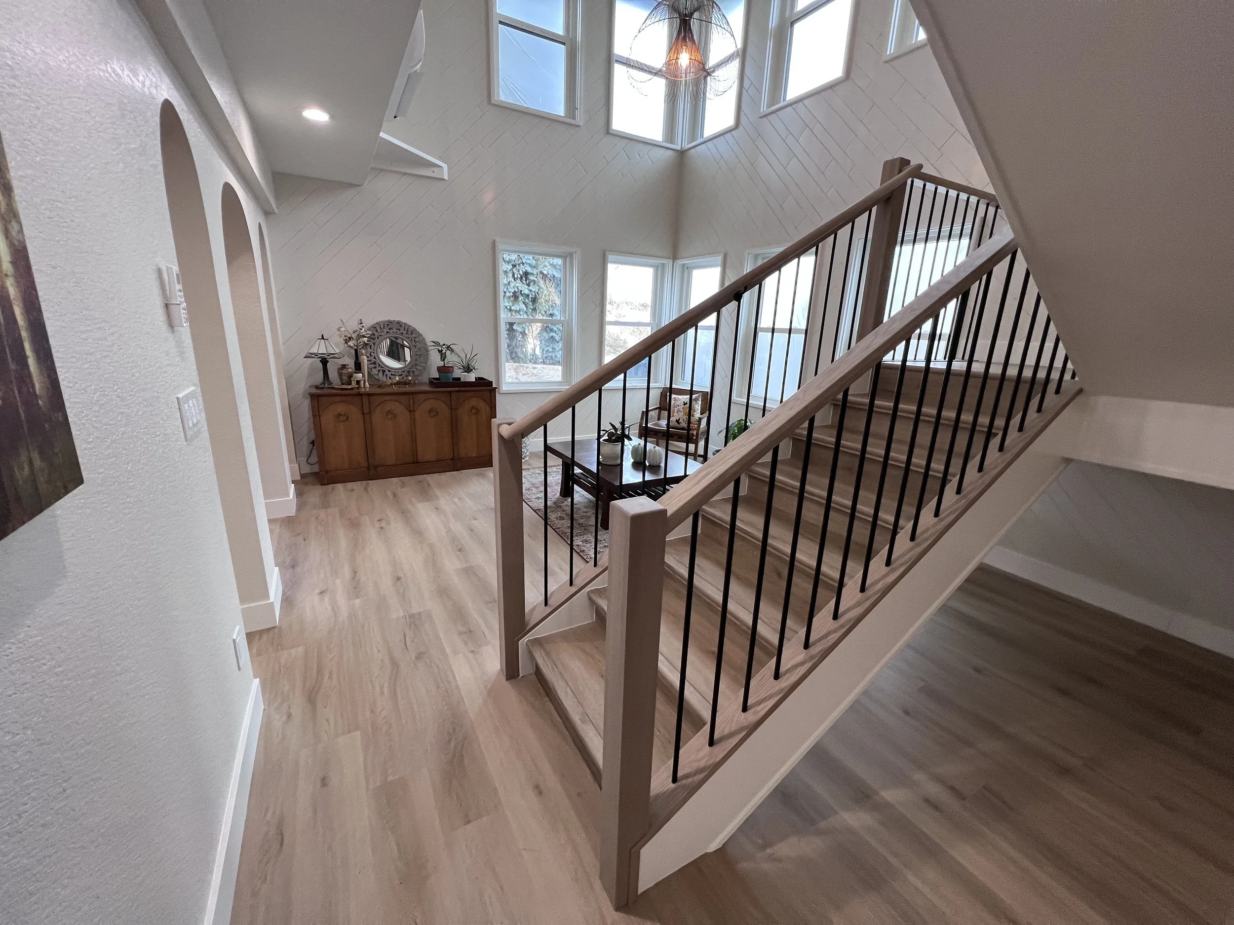 After photo of a redesigned interior staircase with increased natural light following a full interior renovation in Golden, Colorado by Prenvalley Builders.