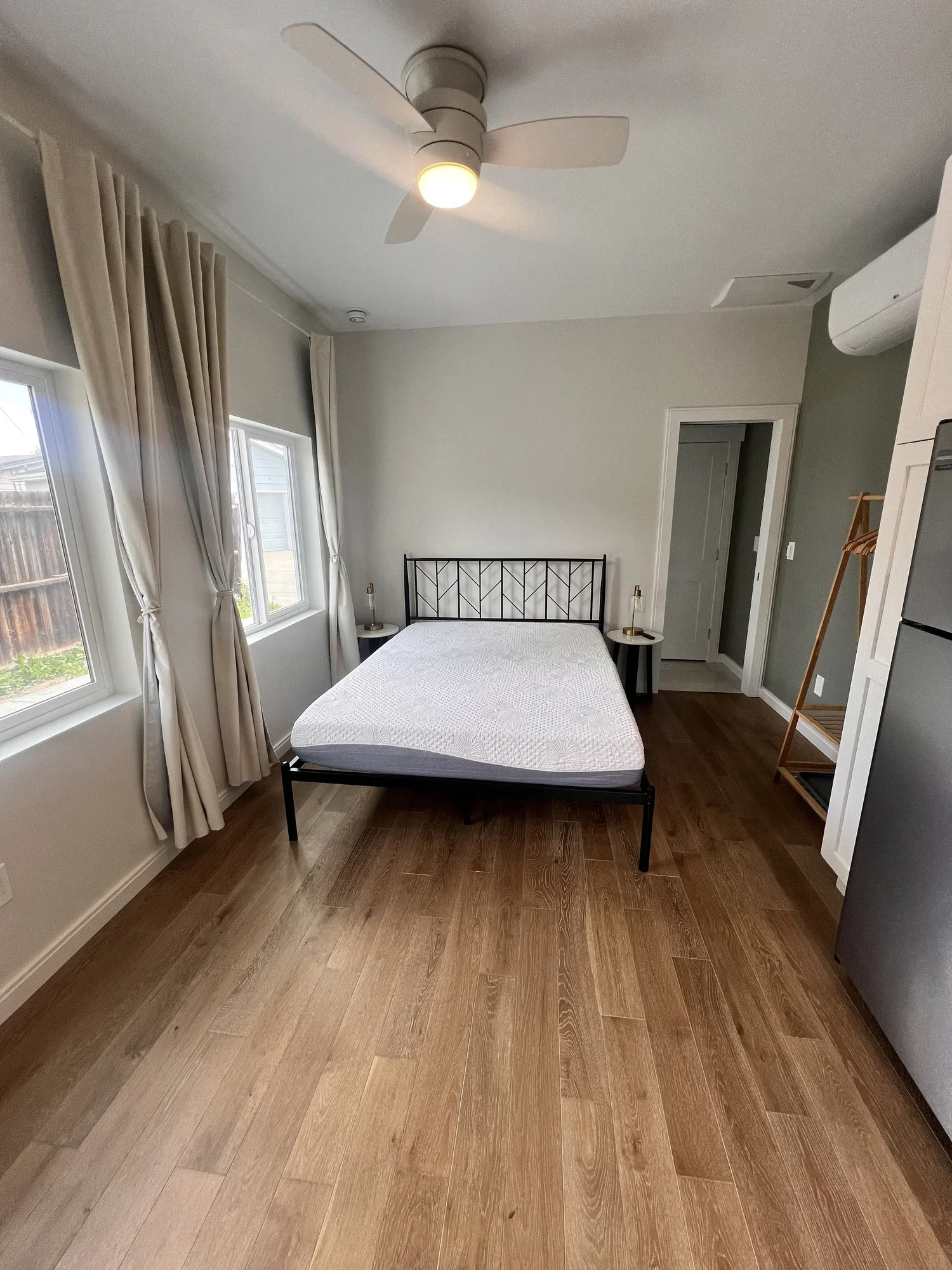 Light-filled ADU bedroom in Denver featuring wood flooring, ceiling fan, and efficient layout designed and built by Prenvalley Builders.