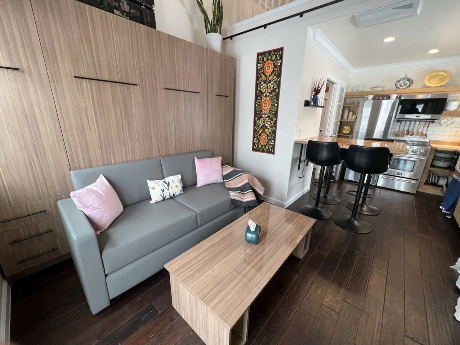 Finished living area inside a detached accessory dwelling unit in Denver, Colorado, built by Prenvalley Builders, featuring integrated storage, a compact sofa, and an open connection to the kitchen.