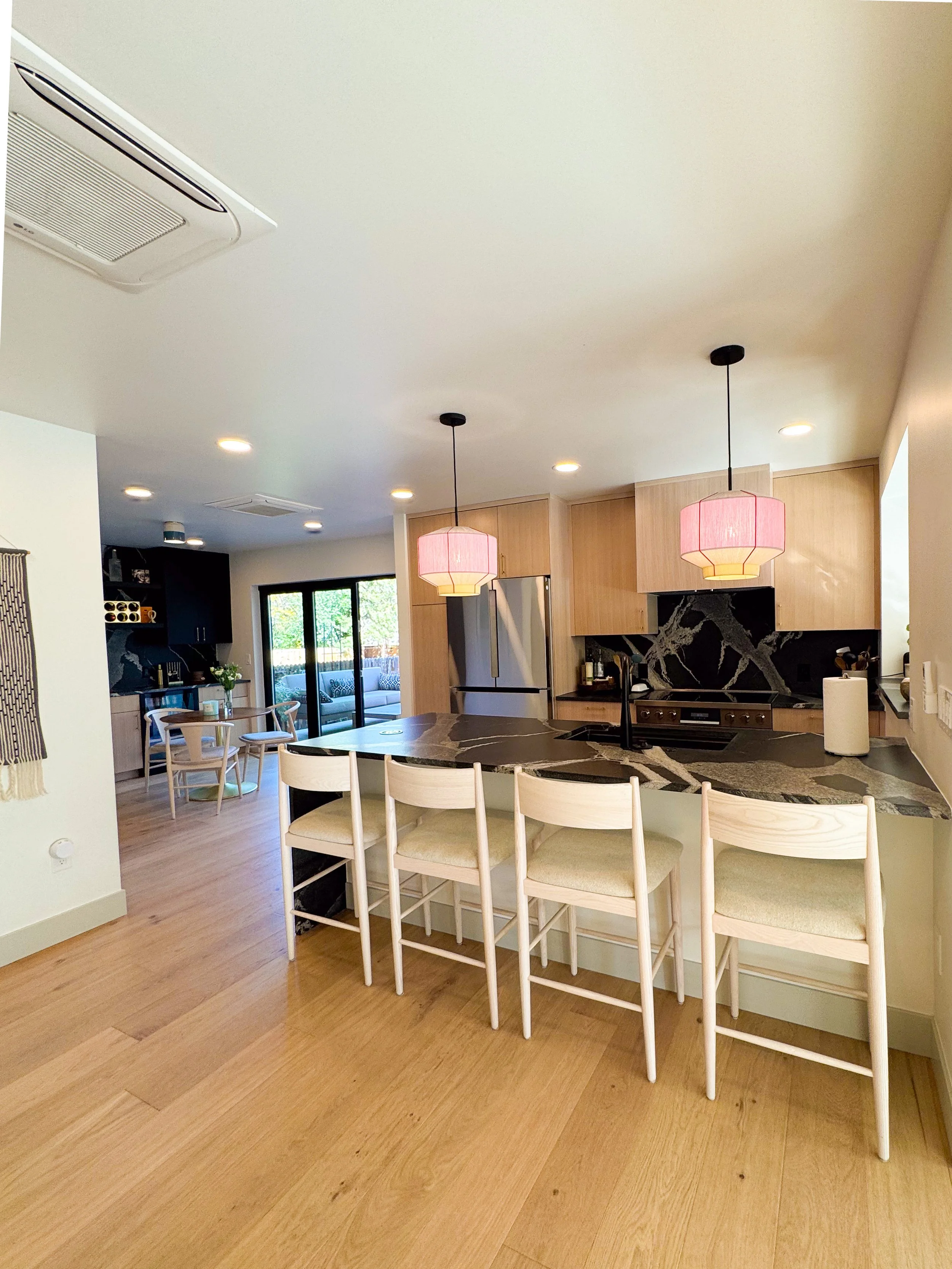 Modern kitchen in a Denver pop-top renovation featuring a large island, custom cabinetry, and integrated dining area