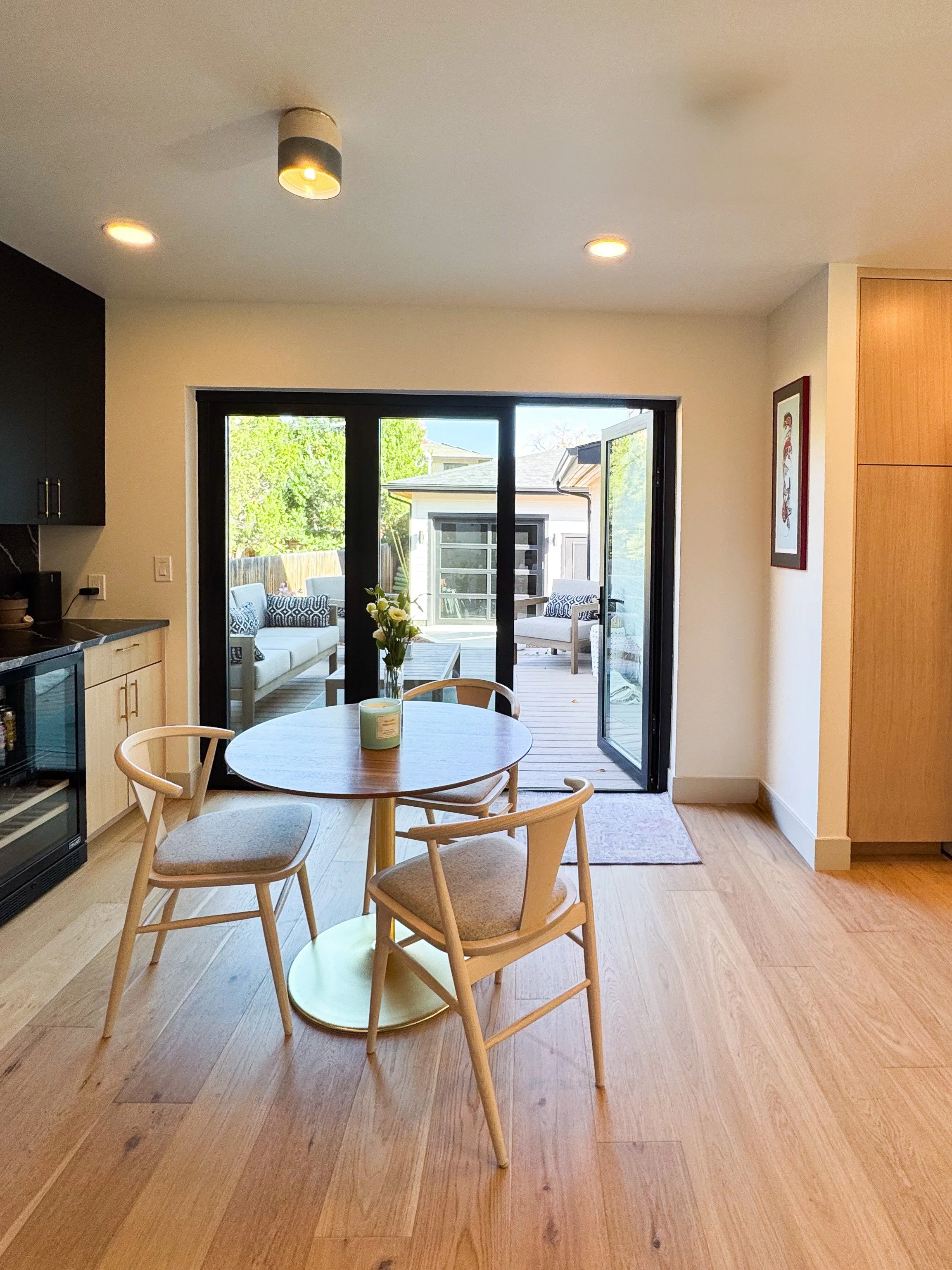 Dining area in a Denver pop-top renovation with large sliding glass doors opening to a rear deck