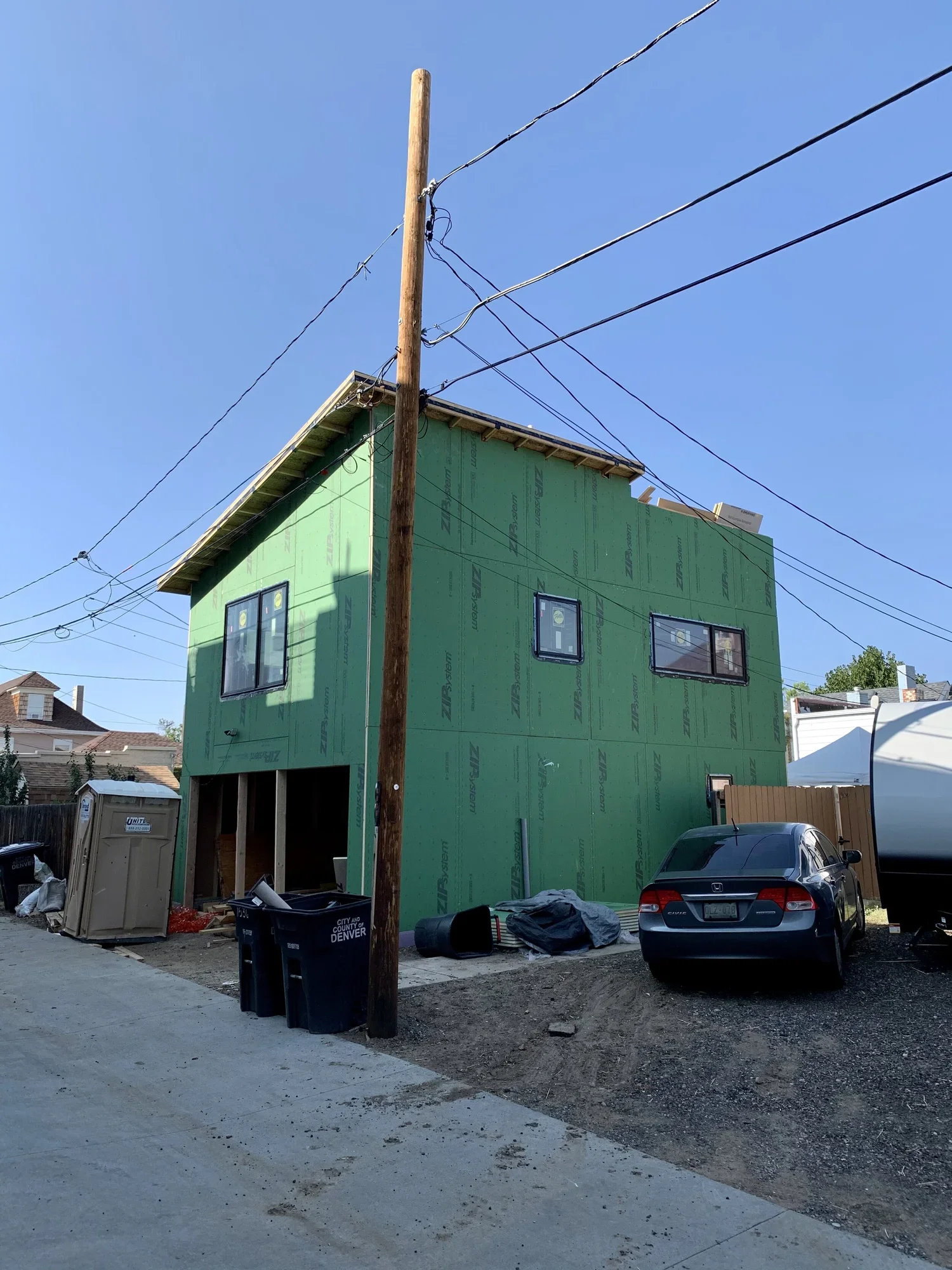 Accessory dwelling unit under construction in Denver showing a garage ADU framed and sheathed on a narrow urban lot with overhead power lines, built by Prenvalley Builders.