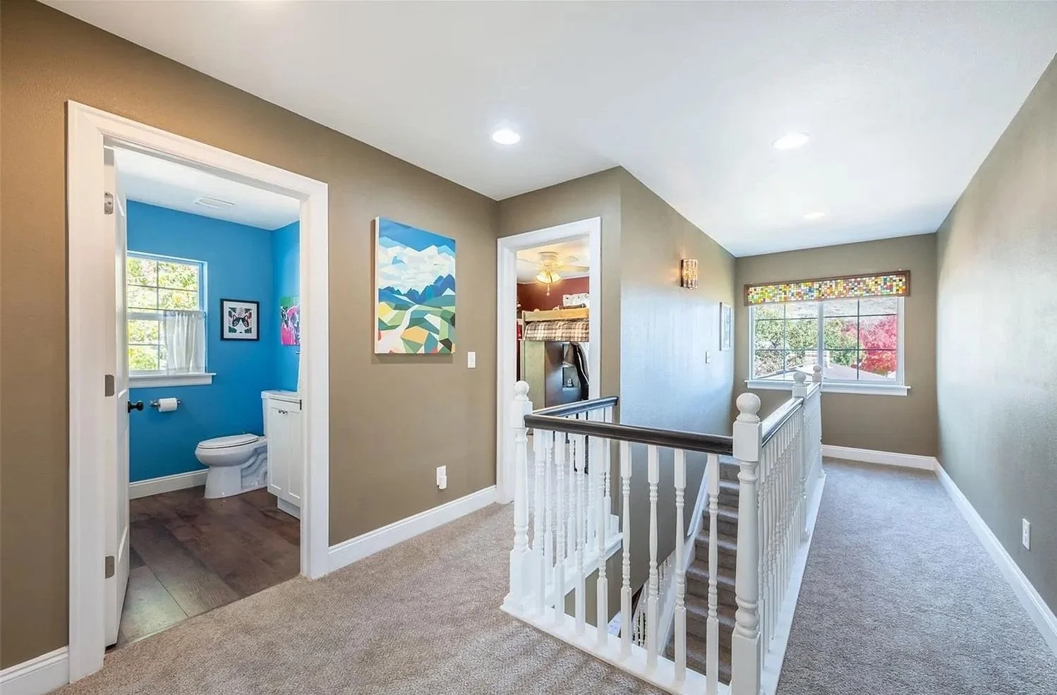 Upper-level hallway and stair landing created as part of a second-story addition in Golden, Colorado, connecting new bedrooms and bathrooms with safe, well-lit circulation by Prenvalley Builders.