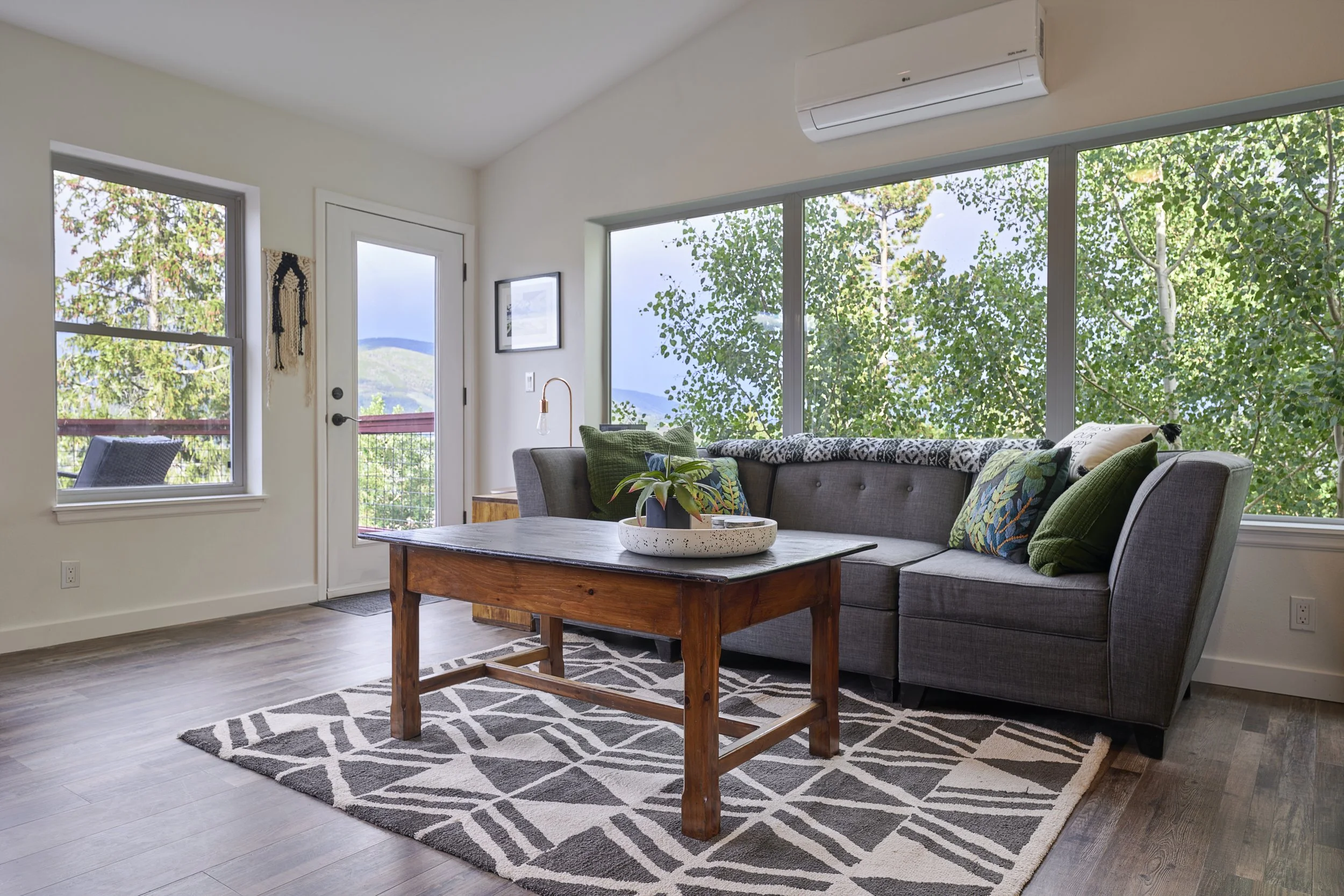 Finished upper-level family space in a Silverthorne pop-top renovation featuring large windows, natural light, and direct access to a balcony with mountain views, completed by Prenvalley Builders.