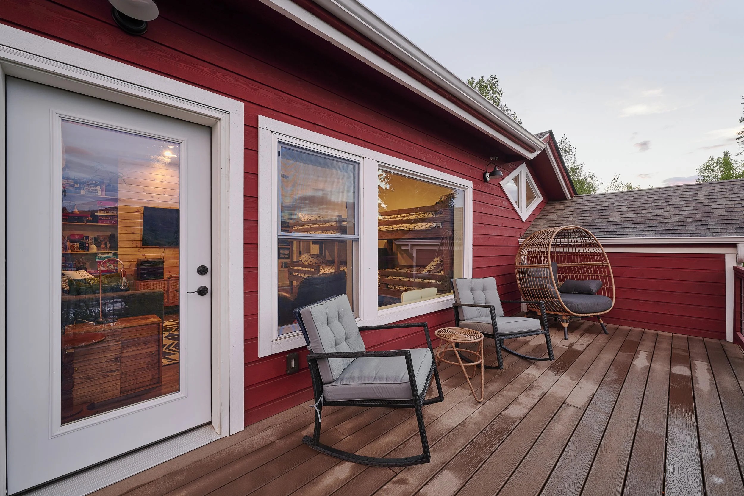 Furnished upper-level balcony in a Silverthorne pop-top renovation, featuring completed decking, seating, and exterior access from the second-story family space, built by Prenvalley Builders.