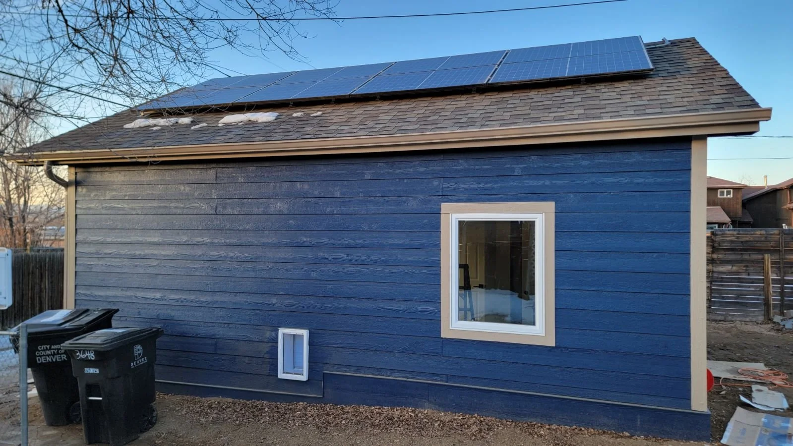 Finished exterior of a detached accessory dwelling unit in Denver with rooftop solar panels, highlighting a compact, energy-conscious ADU built by Prenvalley Builders.
