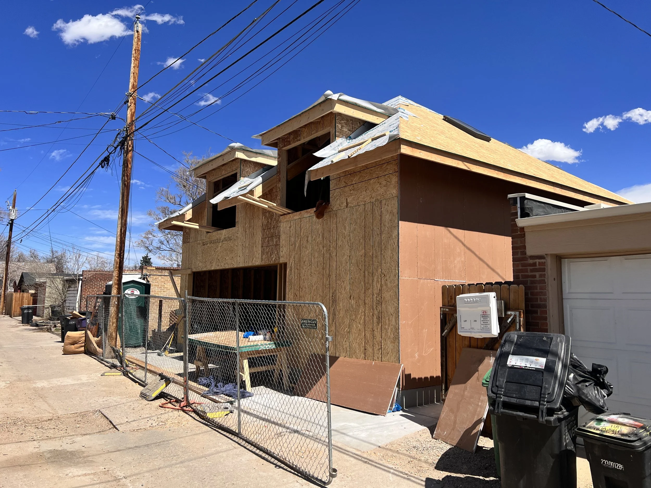 Sheathing and roof assembly in progress on a custom garage ADU in Denver’s Sunnyside neighborhood, showing dormer construction, structural detailing, and envelope preparation by Prenvalley Builders.