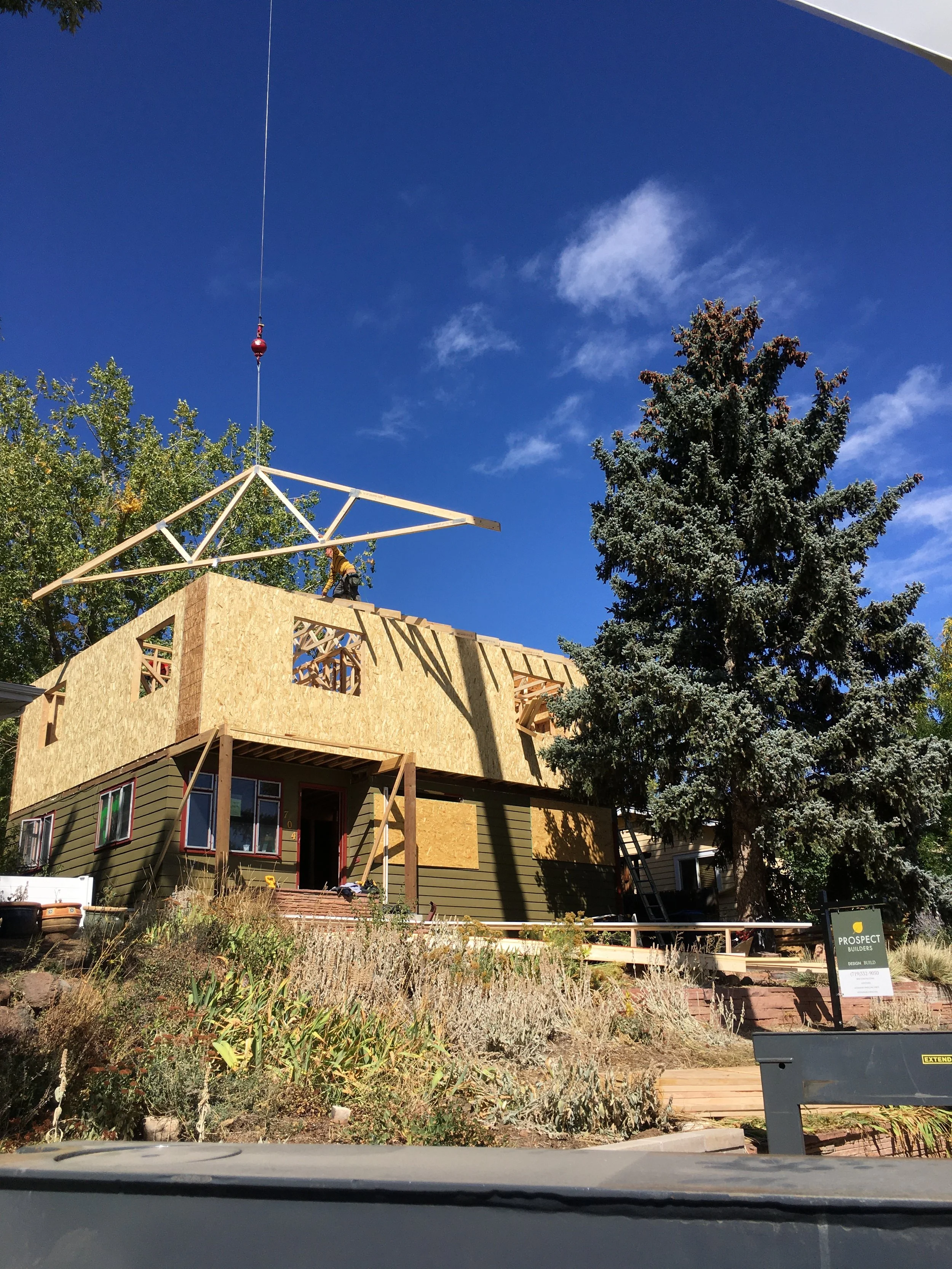 Roof truss installation during construction of a second-story addition in Golden, Colorado, showing crane-set framing as part of a whole-home renovation by Prenvalley Builders.