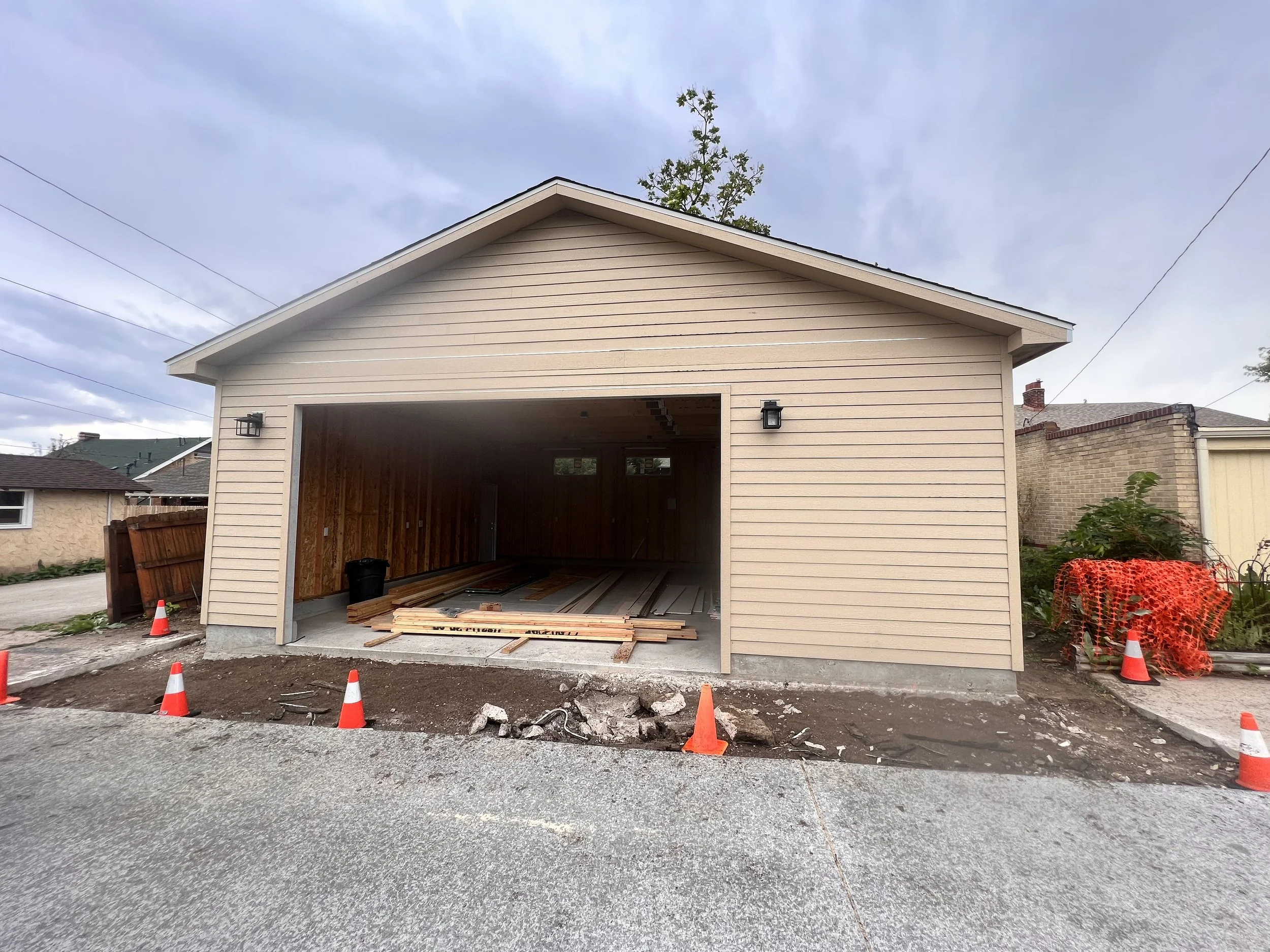 Exterior view of a newly built custom detached garage in Denver, Colorado, featuring horizontal siding, a wide garage opening, and a durable concrete slab foundation by Prenvalley Builders.