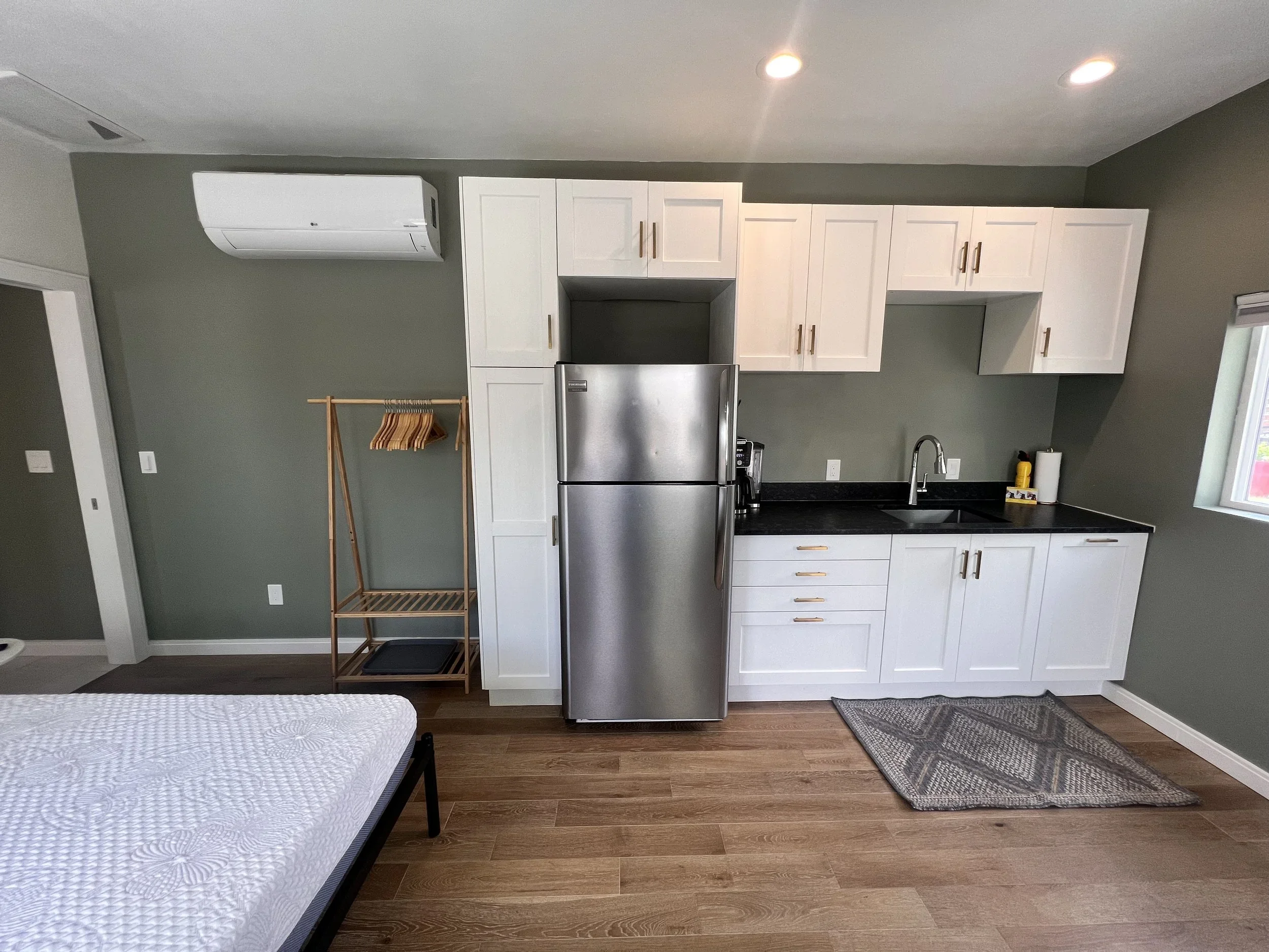 Open-concept garage ADU interior in Denver featuring kitchenette, wood flooring, and efficient layout designed and built by Prenvalley Builders.