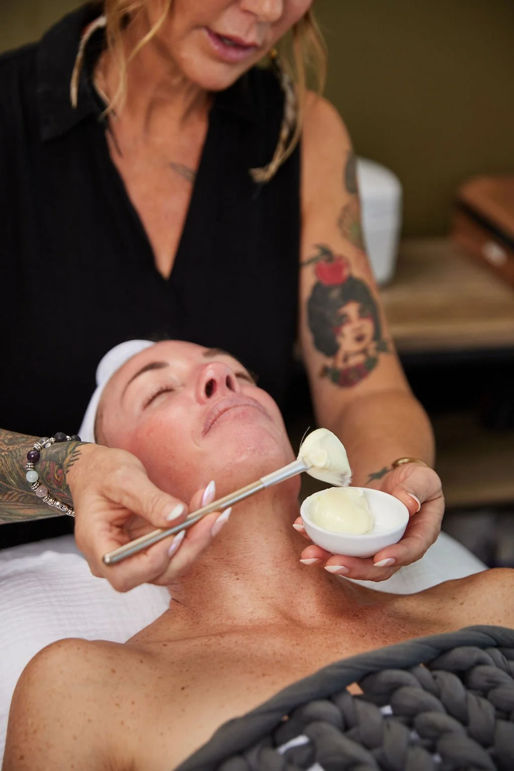 An esthetician applies a masque to a woman's face during a facial at Moonstone Skin & Body Care in Novato, CA