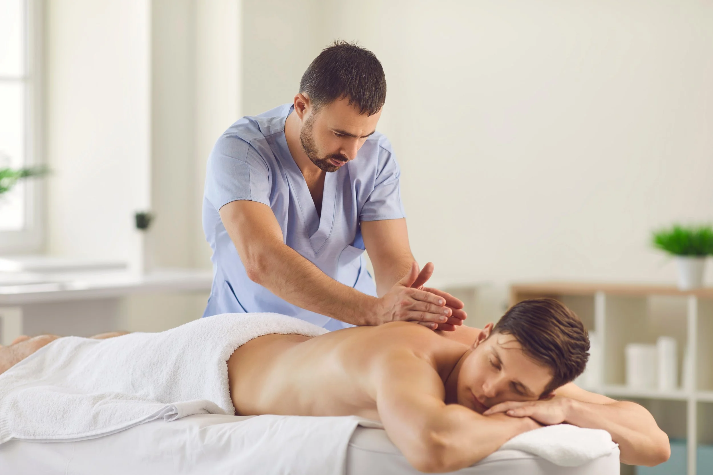 Masseur giving a male client a massage