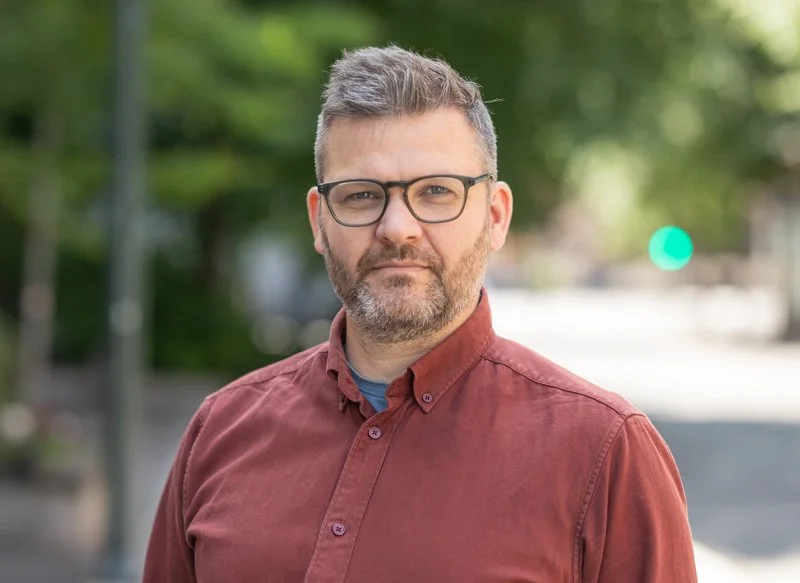 mann i rød skjorte og briller